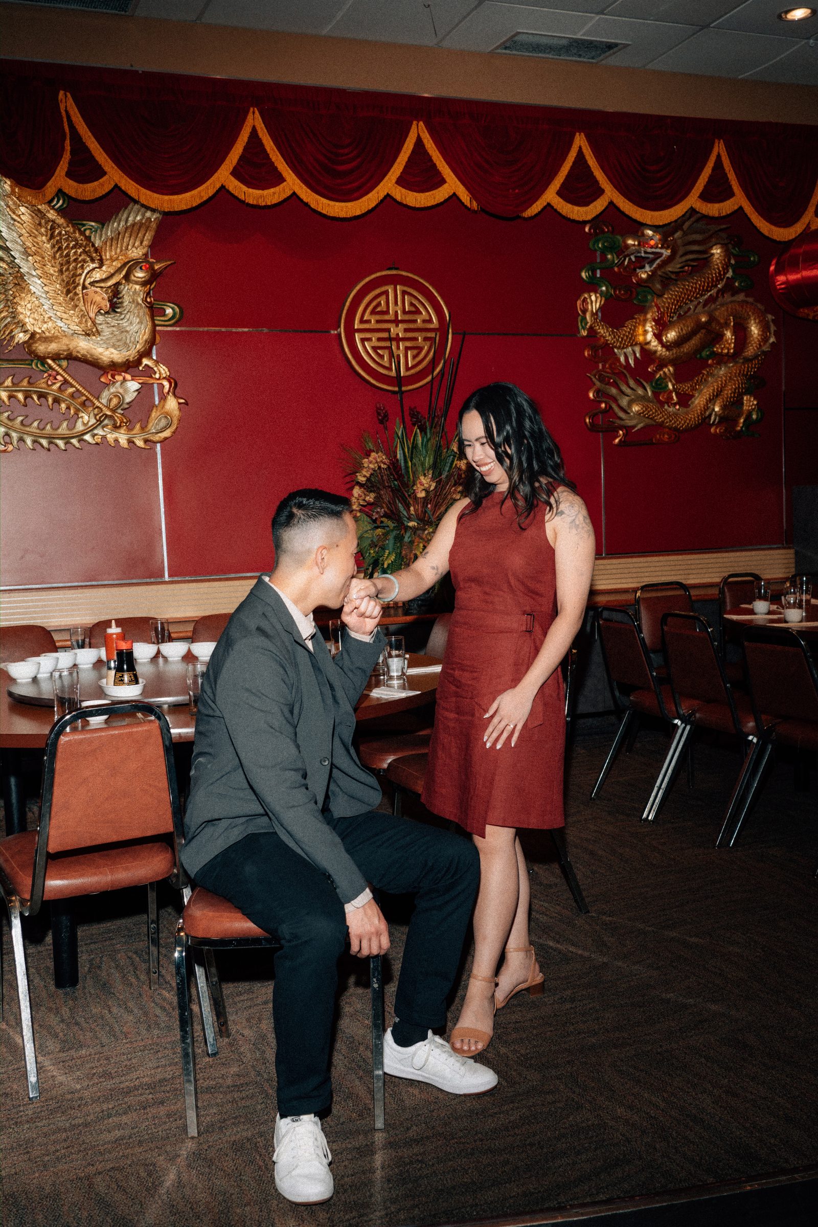 Jason and Monica laughing at their table in Kum Koon Garden Winnipeg — Chinese restaurant engagement session by Chris Ngo
