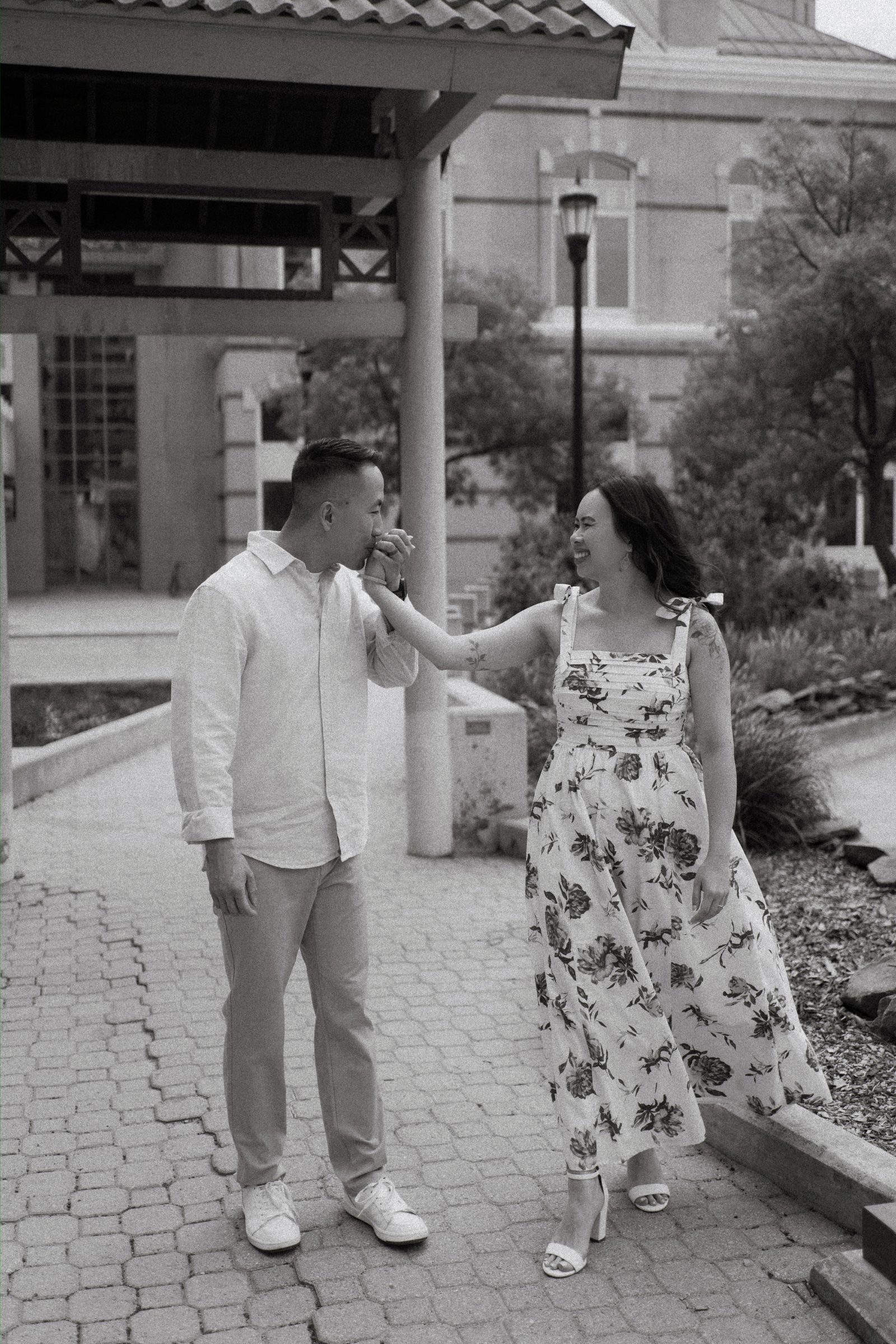 Monica and Jason in the Chinatown garden under the red pagoda roof in Winnipeg — engagement photography by Ngo Photography