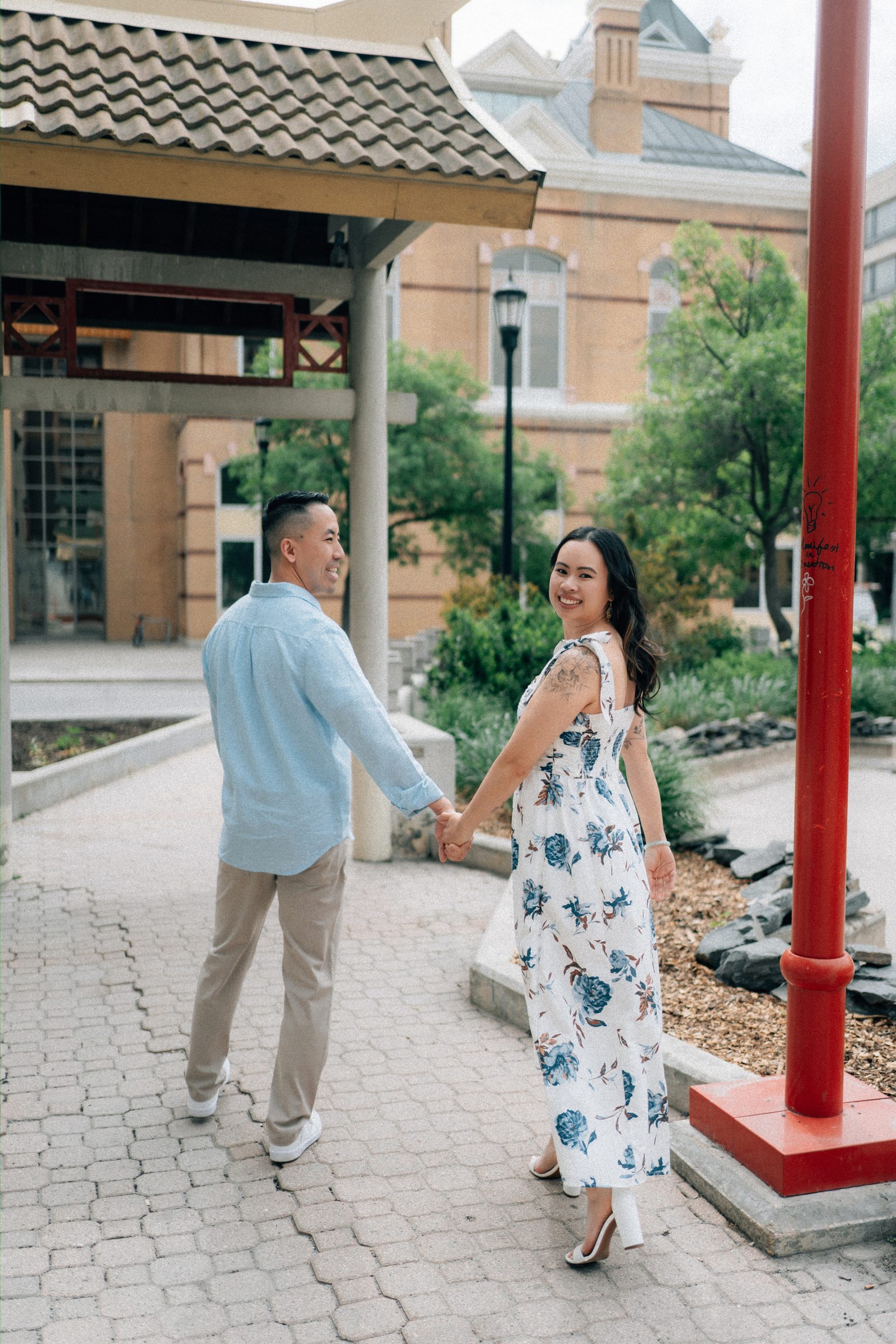 Couple portrait in Winnipeg Chinatown with traditional Chinese pagoda architecture — engagement photography by Chris Ngo