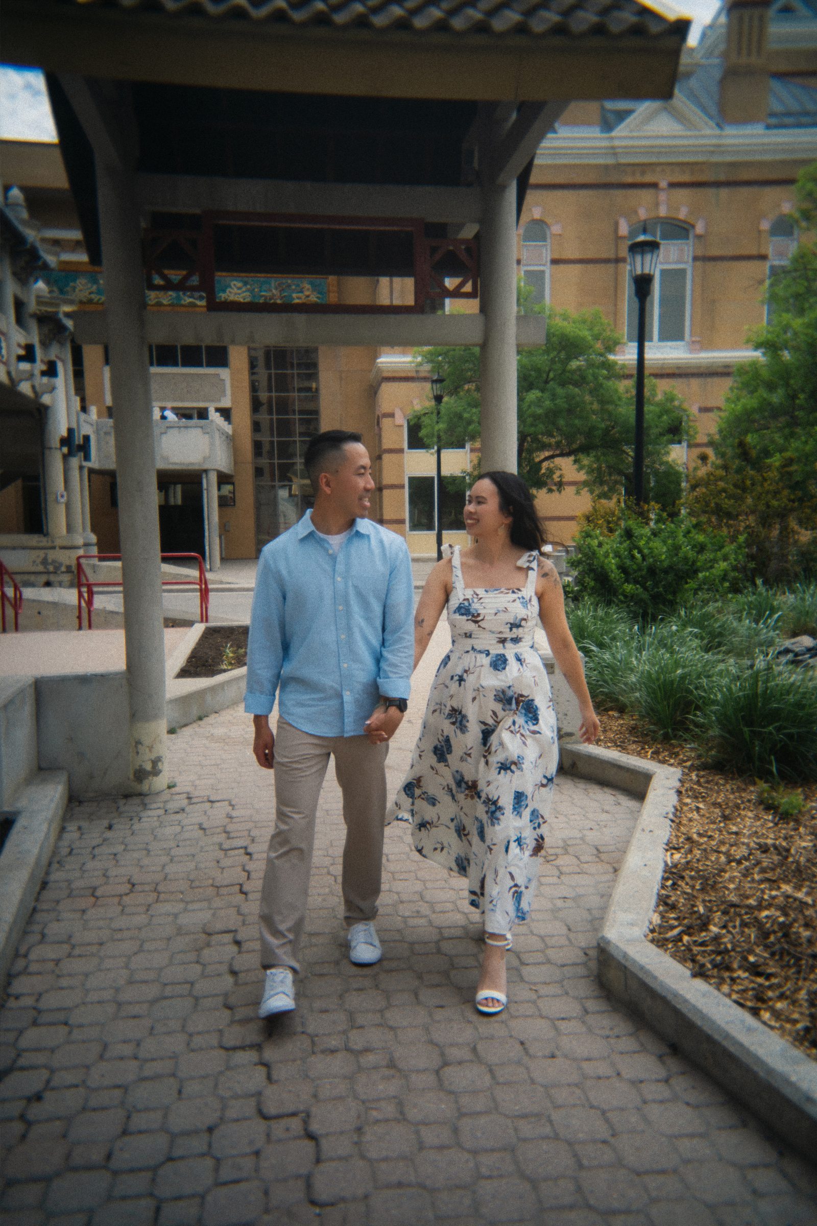 Monica looking over her shoulder in Winnipeg's Chinatown garden — Chinese heritage engagement session by Ngo Photography