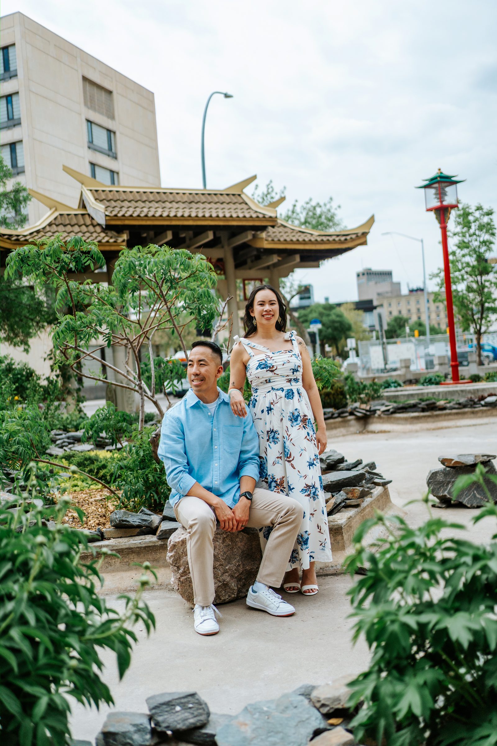 Monica and Jason walking through Winnipeg Chinatown's ceremonial garden — Chinese Vietnamese cultural engagement session by Ngo Photography