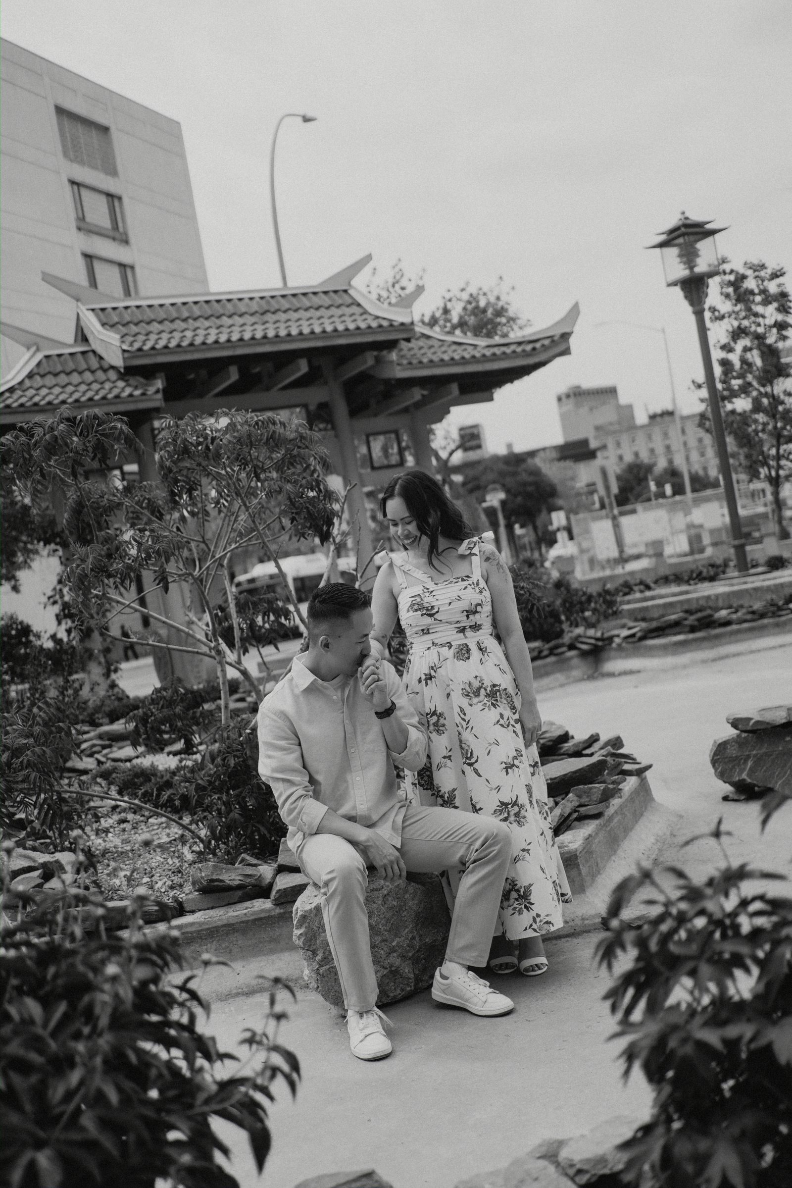 Close portrait of Monica and Jason against the red pagoda columns in Winnipeg Chinatown — engagement photography by Chris Ngo