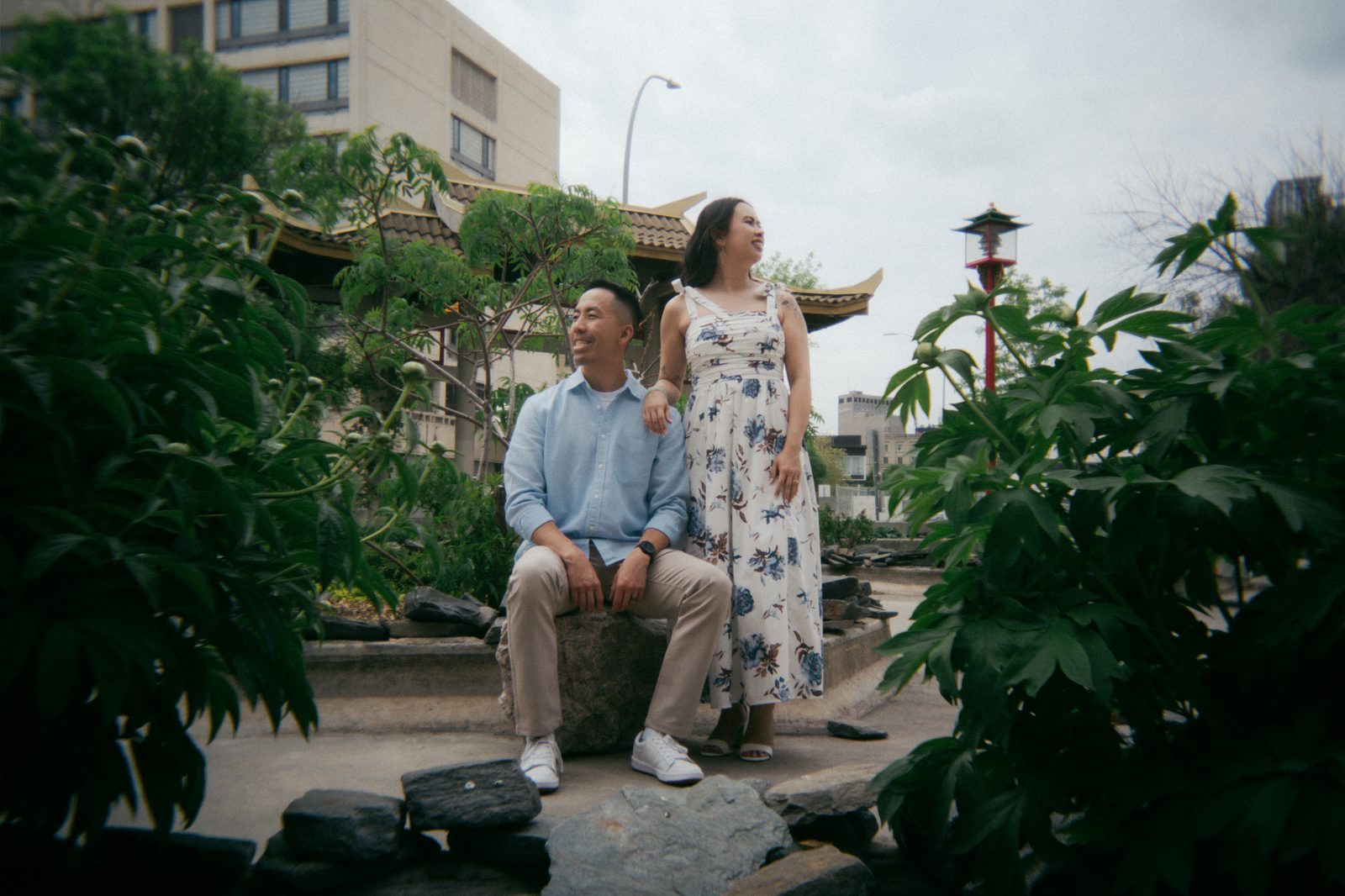 Monica and Jason embracing in the Chinatown garden Winnipeg — Chinese inspired engagement session by Ngo Photography