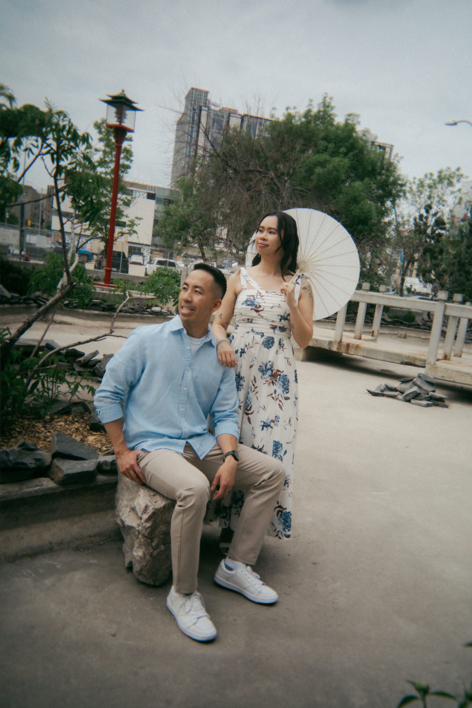 Jason spinning Monica in Winnipeg Chinatown with pagoda architecture in background — Chinese inspired engagement photos by Ngo Photography