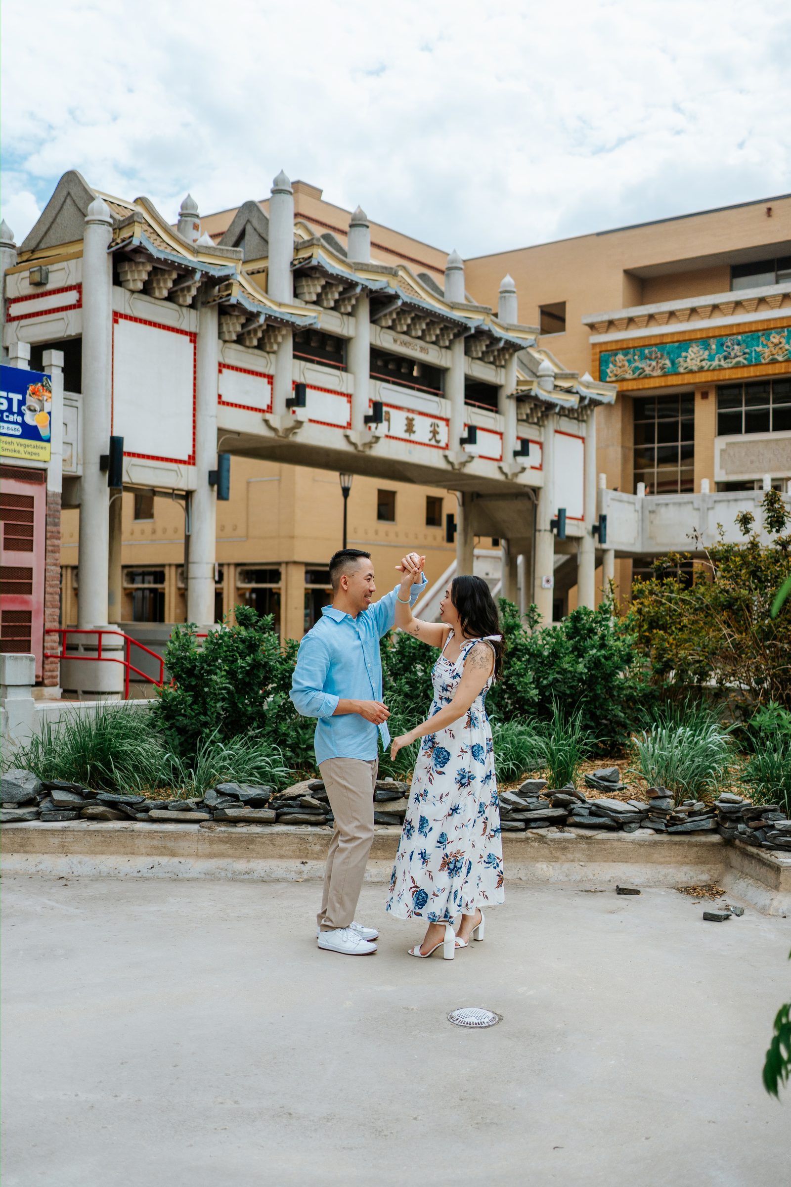 Monica and Jason portrait on the steps of Winnipeg Chinatown landmark — engagement photography by Ngo Photography