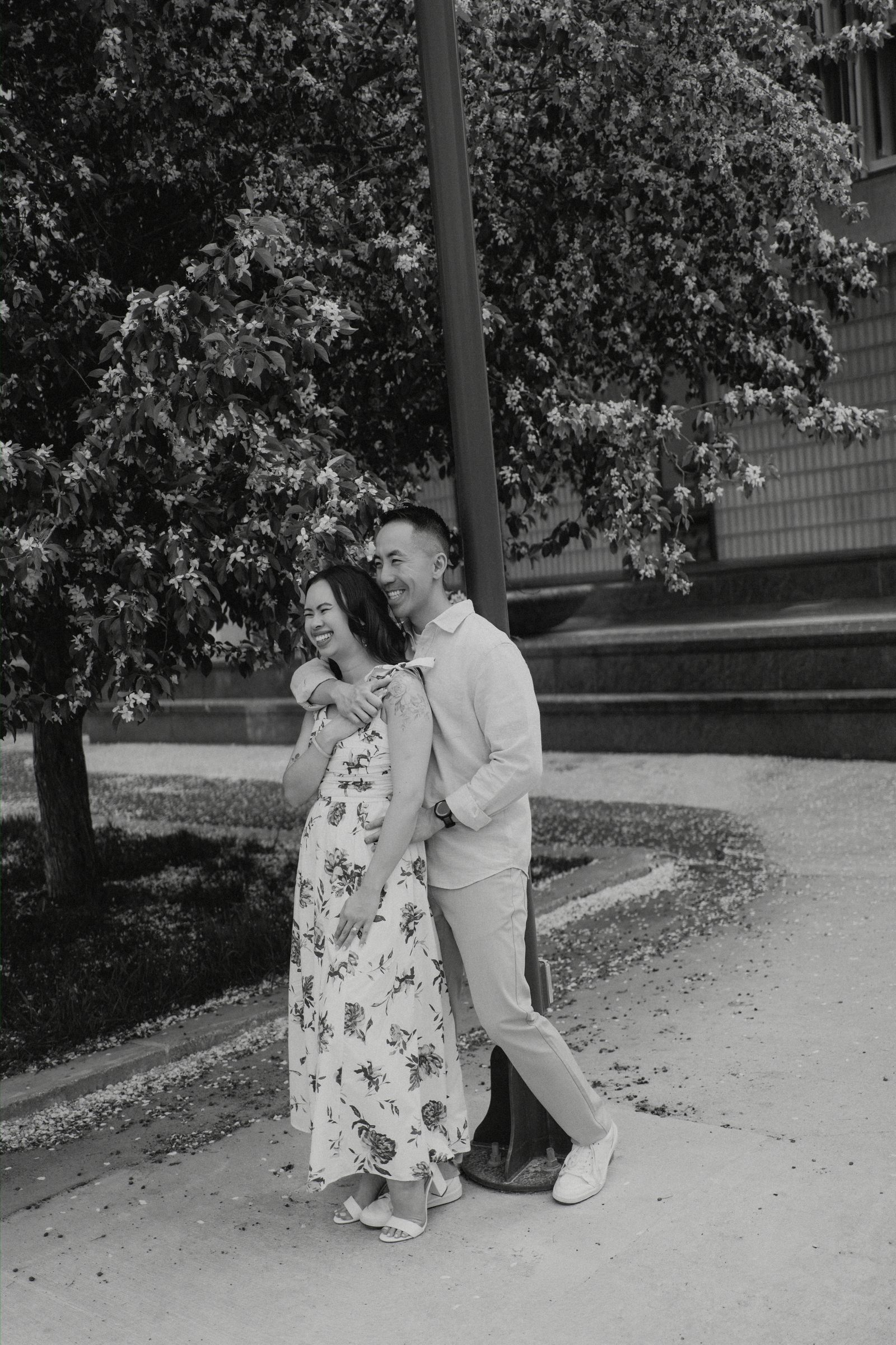 Monica and Jason portrait near blossoming trees in Winnipeg Chinatown — Chinese Vietnamese engagement photography by Chris Ngo