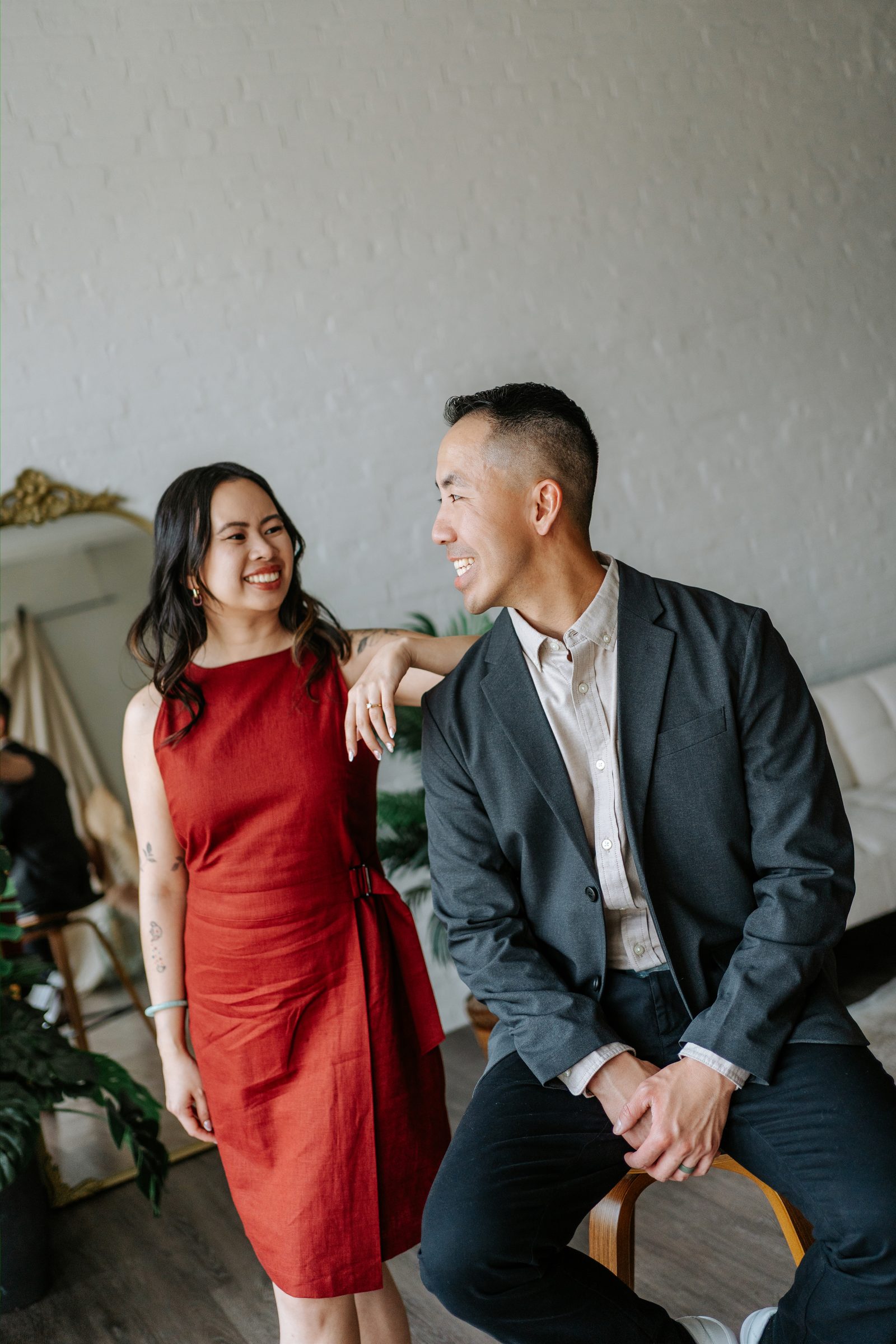 Monica in a red dress and Jason in a charcoal blazer — second look for Winnipeg Chinatown engagement session by Ngo Photography