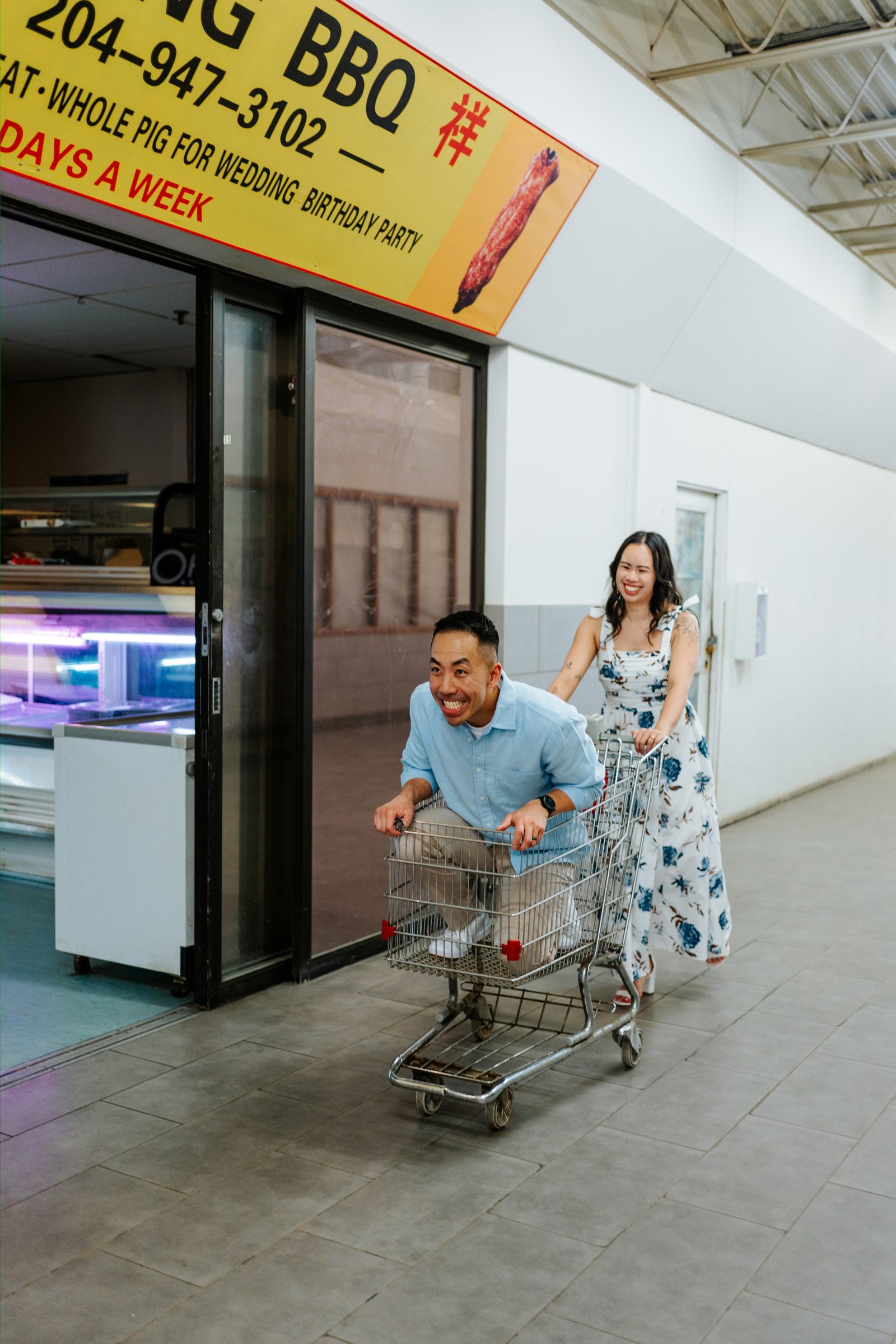 Monica and Jason laughing together inside Sun-Wah grocery market Winnipeg — Chinese engagement photography by Chris Ngo