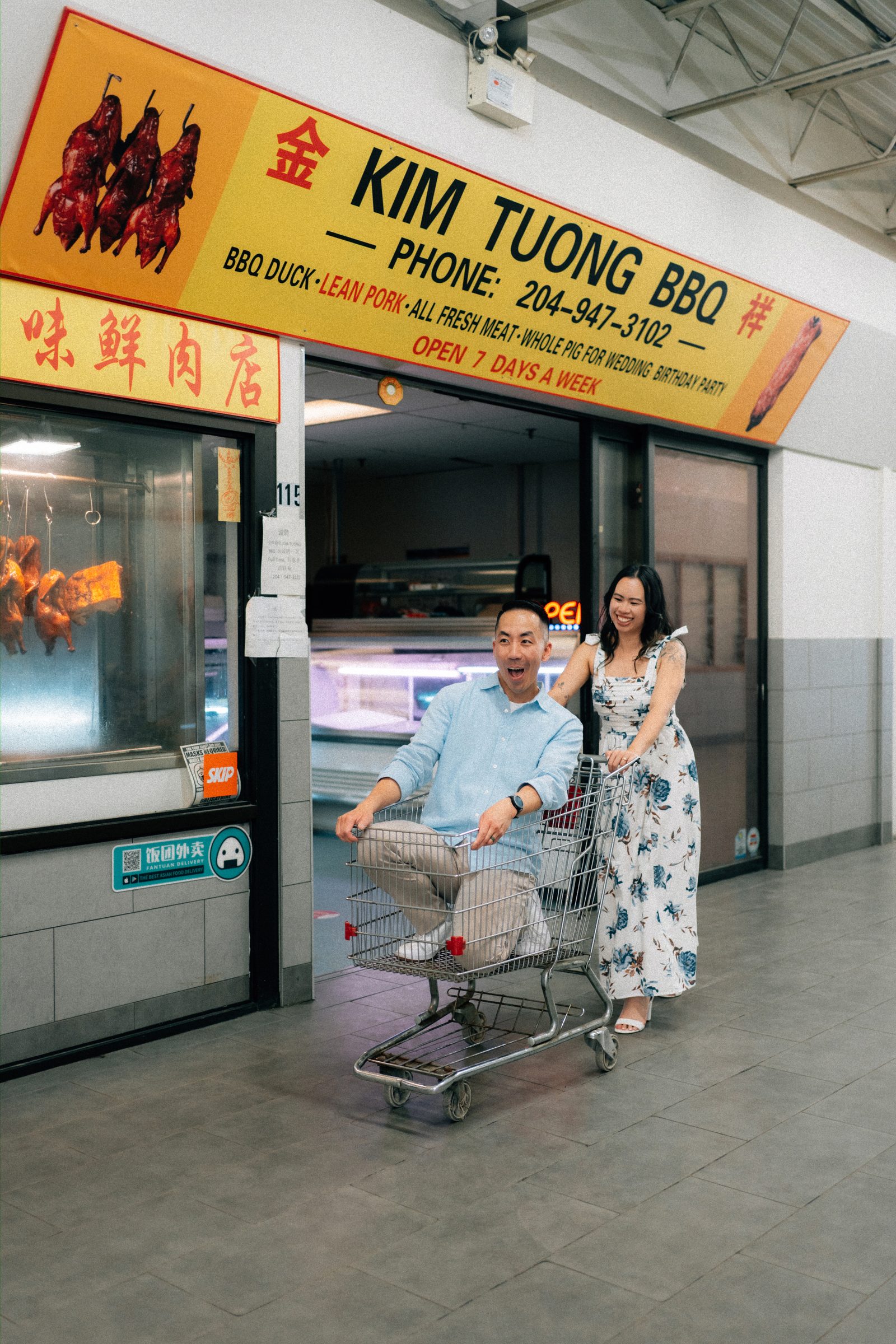 Monica and Jason in the grocery aisles of Sun-Wah Centre Chinatown with bilingual Chinese Vietnamese English signs — Winnipeg engagement photos by Ngo Photography