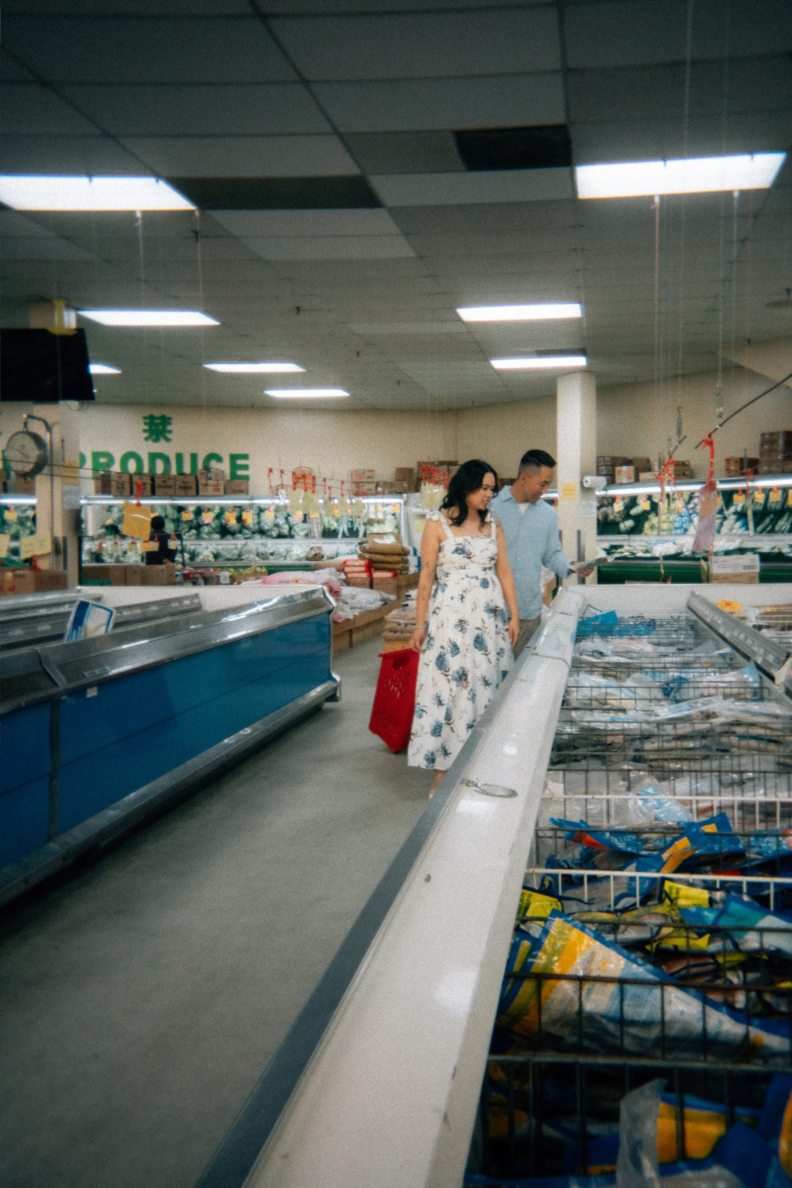 Monica and Jason candid moment near canned goods at Sun-Wah Centre Chinatown — engagement photography by Ngo Photography