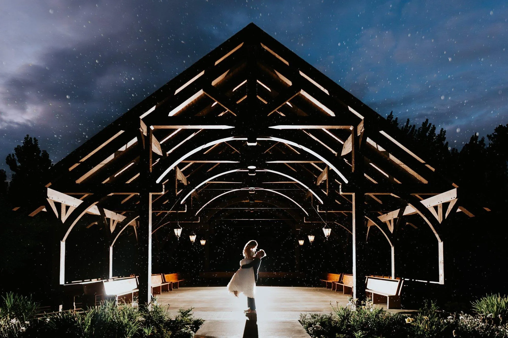 Couple under lit pavilion at night — Manitoba wedding photography