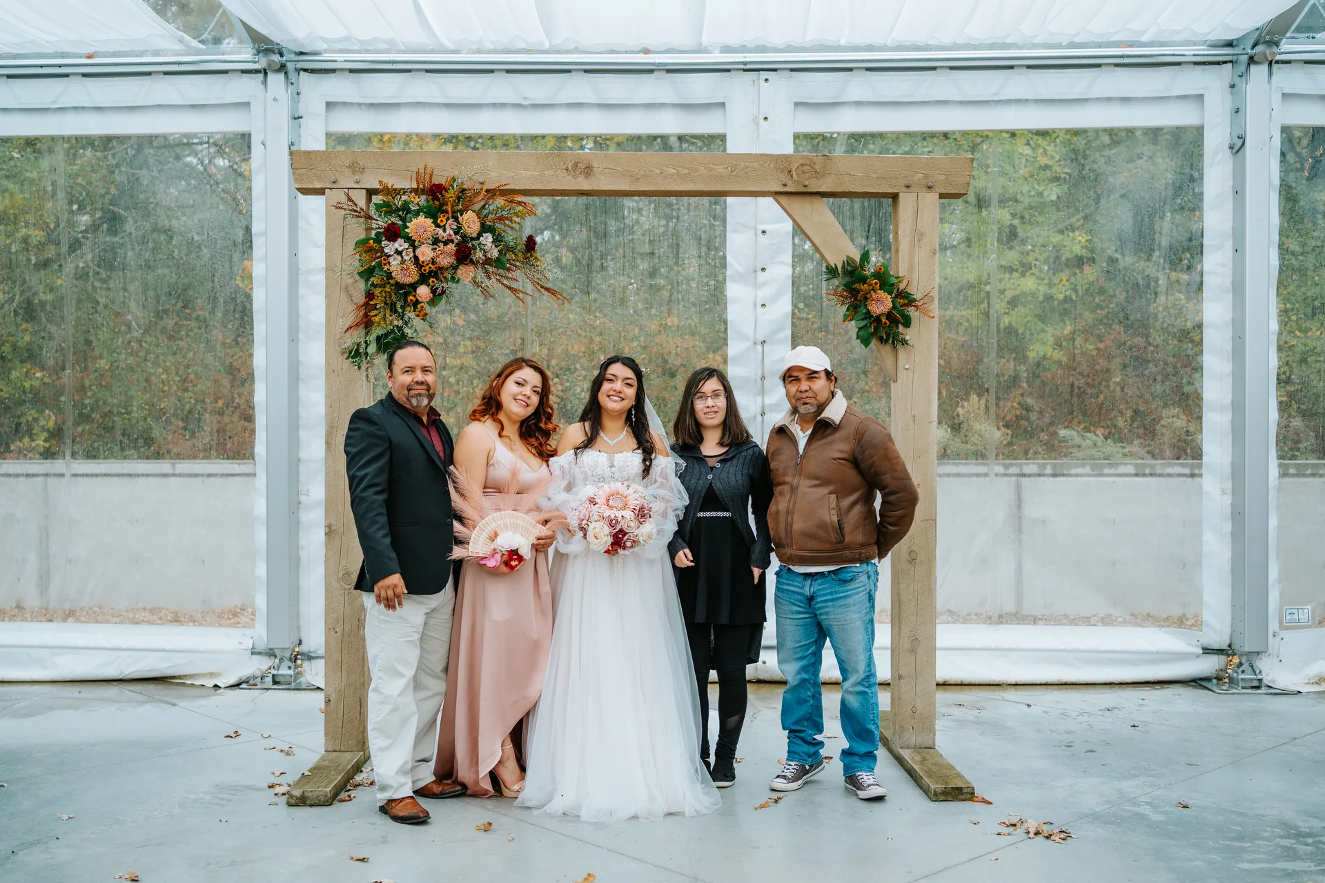 Bride Paola and family formals at the wooden arch with autumn oak trees at Oakland Estates Manitoba wedding