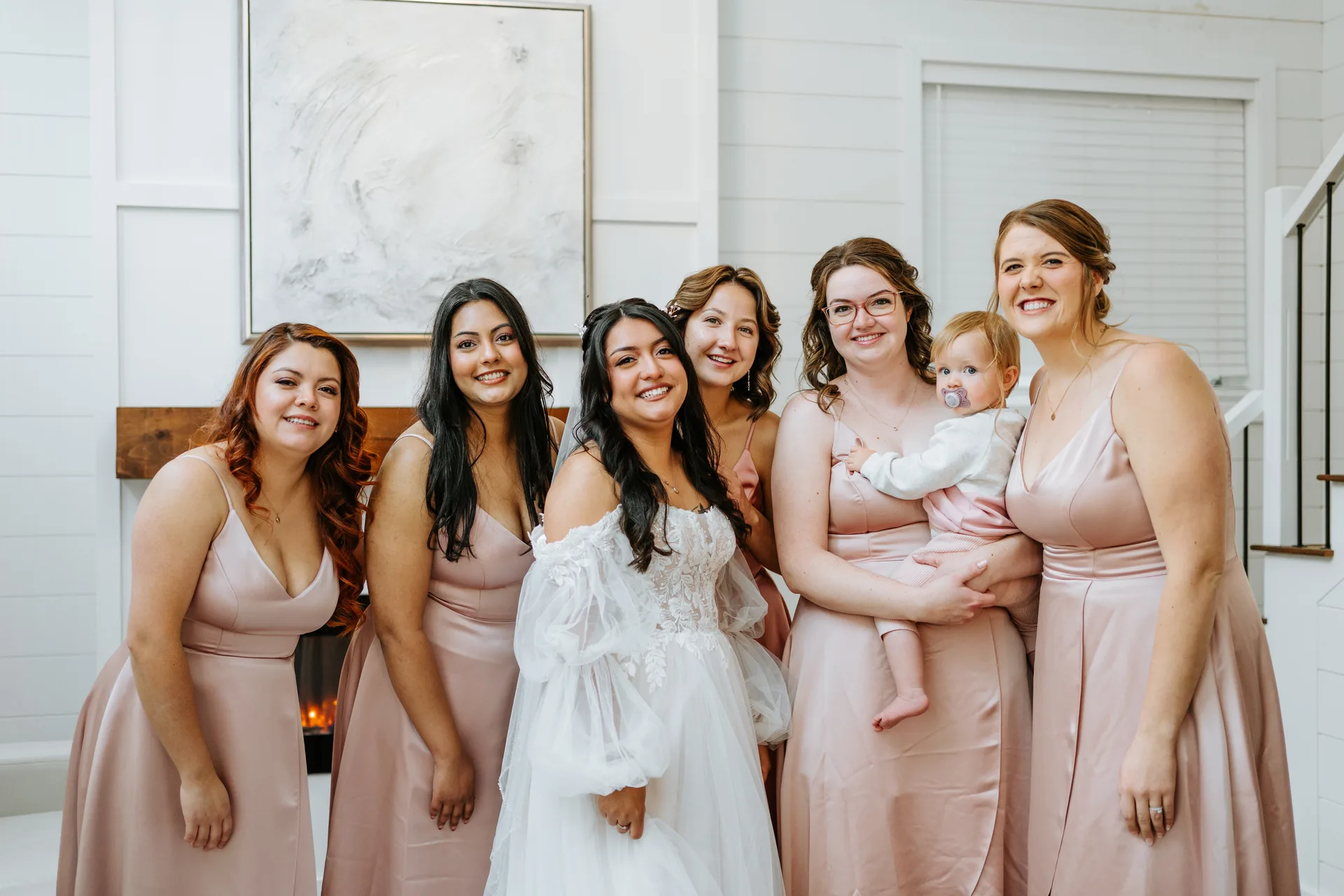 Bride Paola with bridesmaids in blush satin dresses during getting ready at Oakland Estates Manitoba