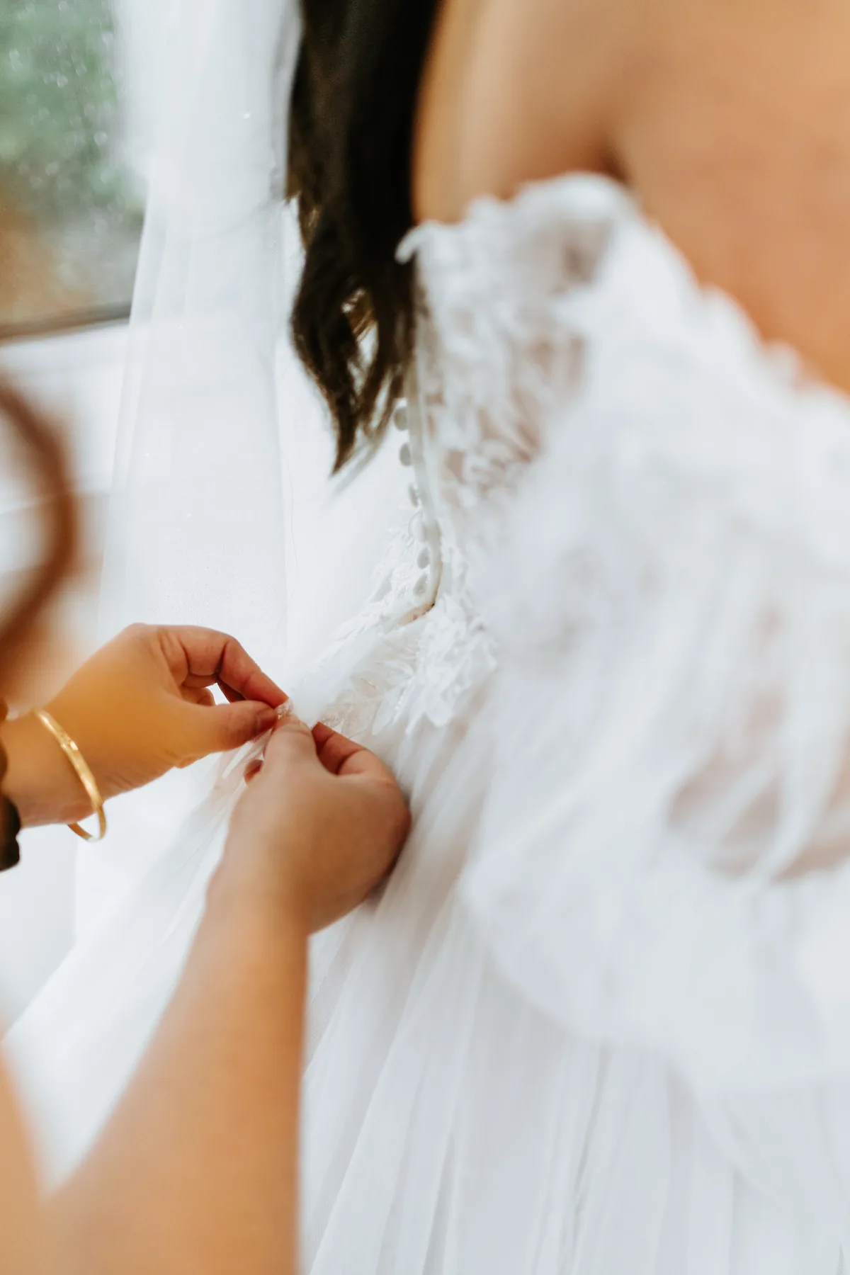 Bride Paola having hair and makeup done during getting ready at Oakland Estates Manitoba