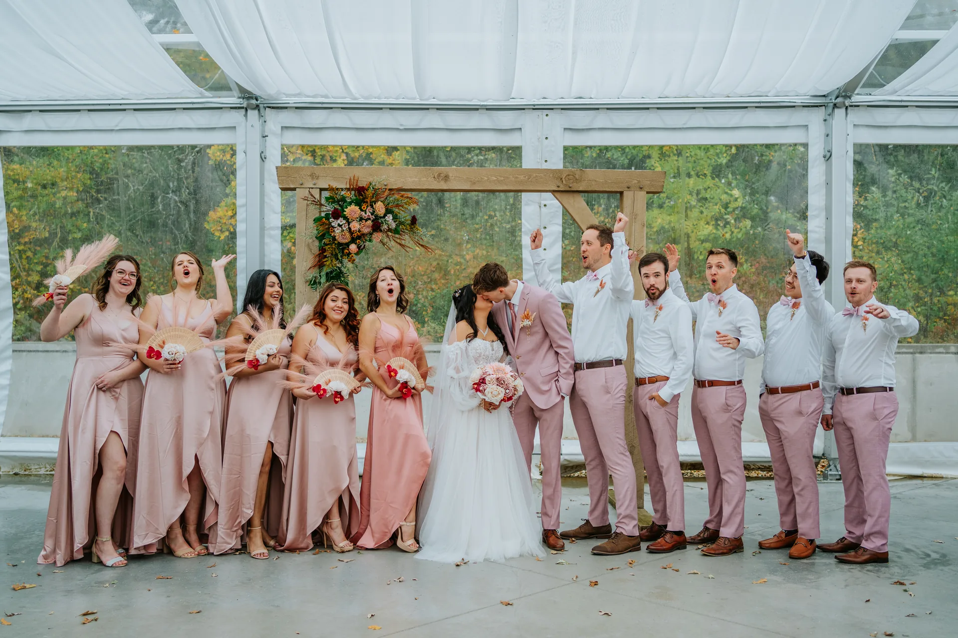 Bridesmaids and groomsmen group portrait outdoors in fall foliage at Oakland Estates Manitoba wedding