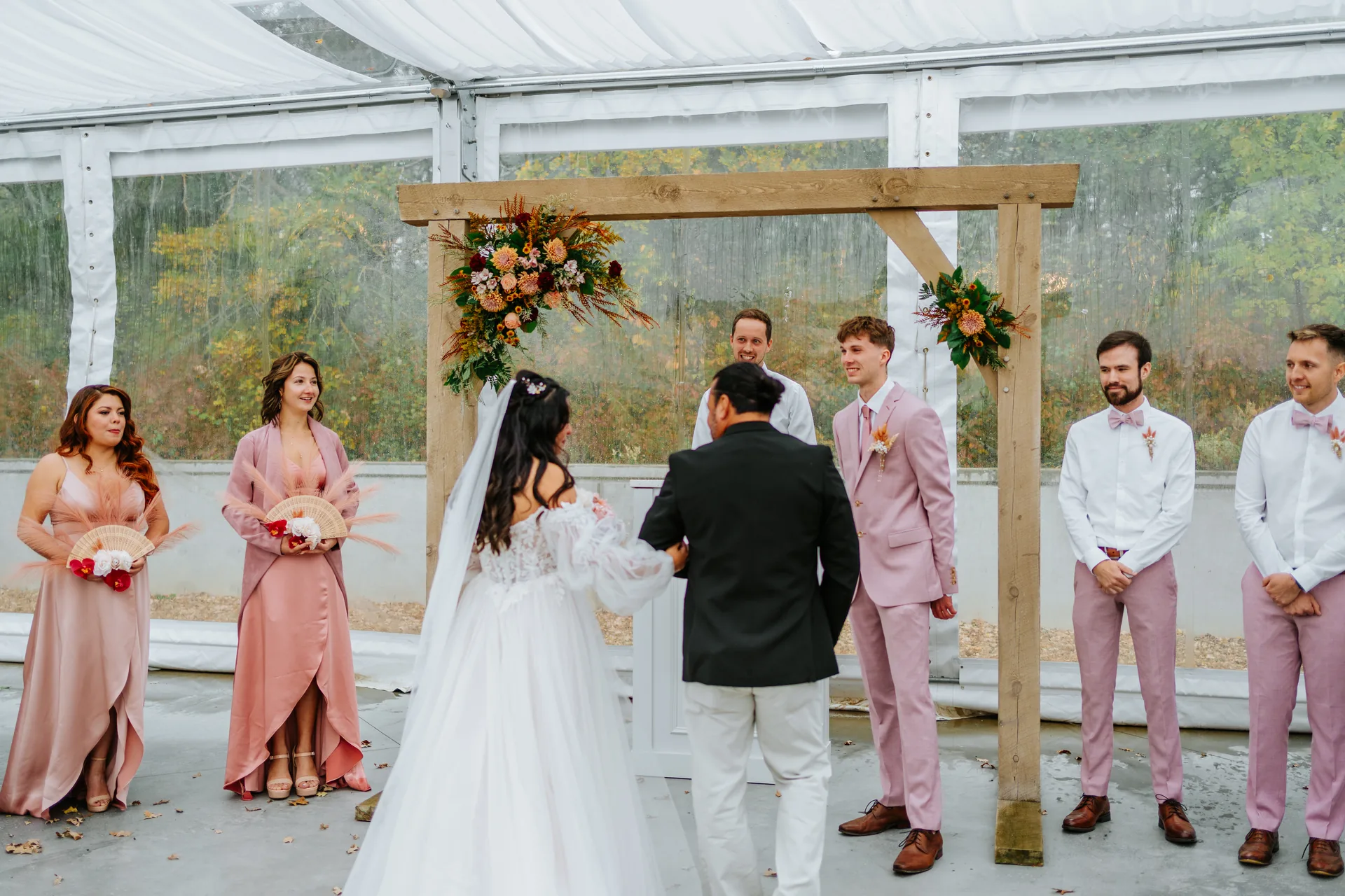 Wedding guests seated for ceremony inside the glass marquee tent at Oakland Estates Manitoba — Ngo Photography