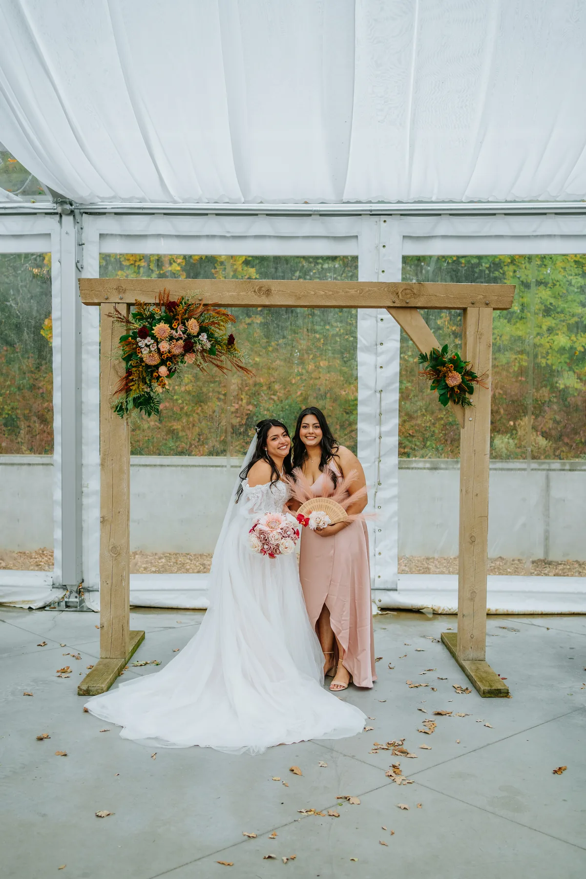 Paola and Riley embracing in fall trees at Oakland Estates Manitoba wedding — photography by Ngo Photography