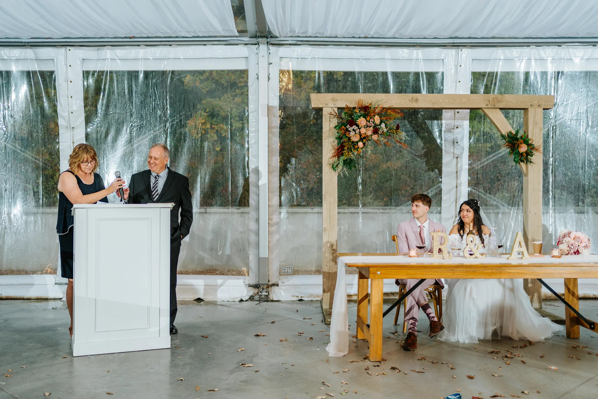 Parent toast speech with couple at head table inside the glass tent at Oakland Estates Manitoba wedding