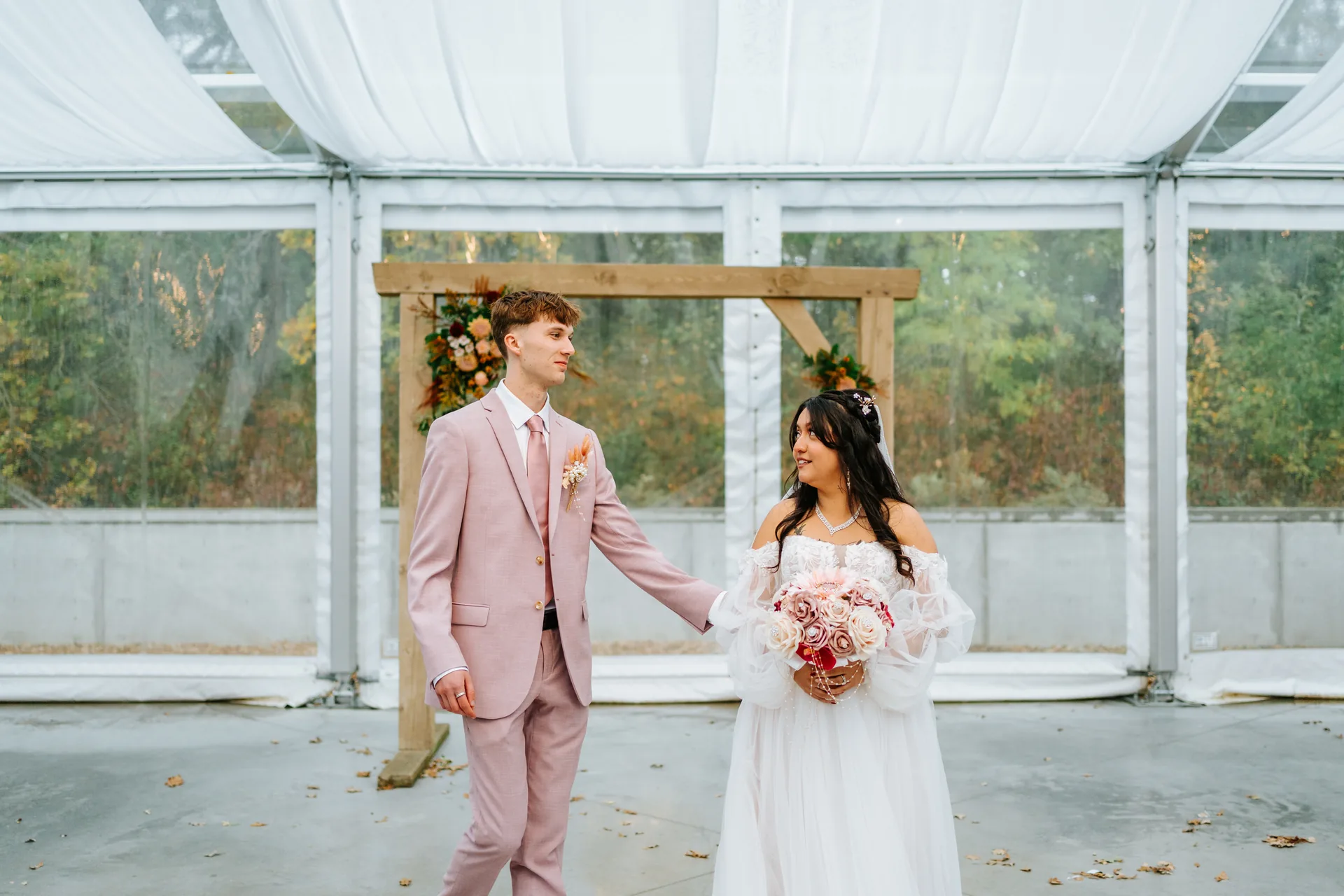 Guests laughing and mingling inside the glass tent at Oakland Estates Manitoba reception — Ngo Photography