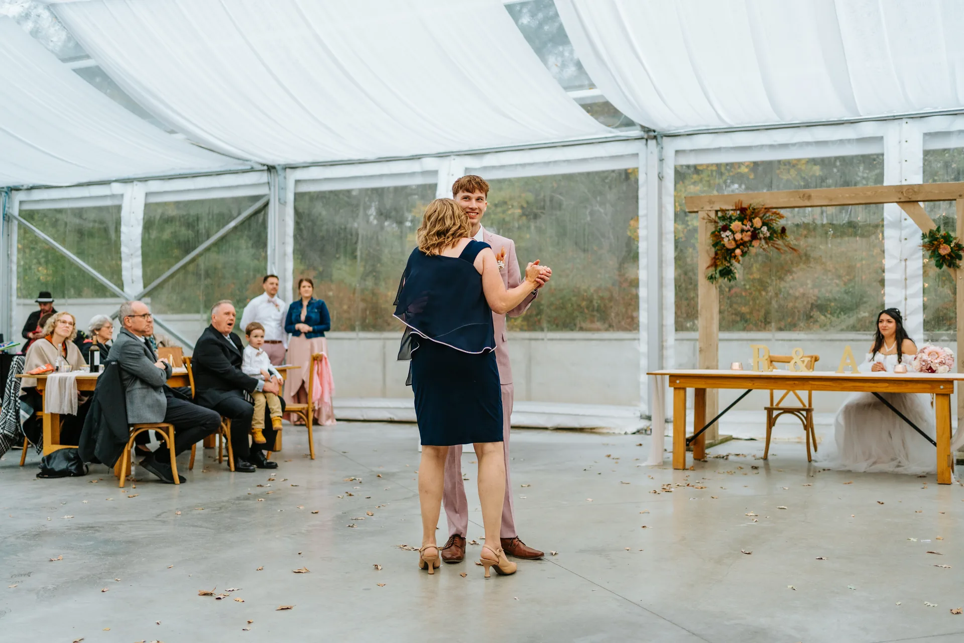 Champagne toast at farm tables during Oakland Estates Manitoba wedding reception — photography by Chris Ngo