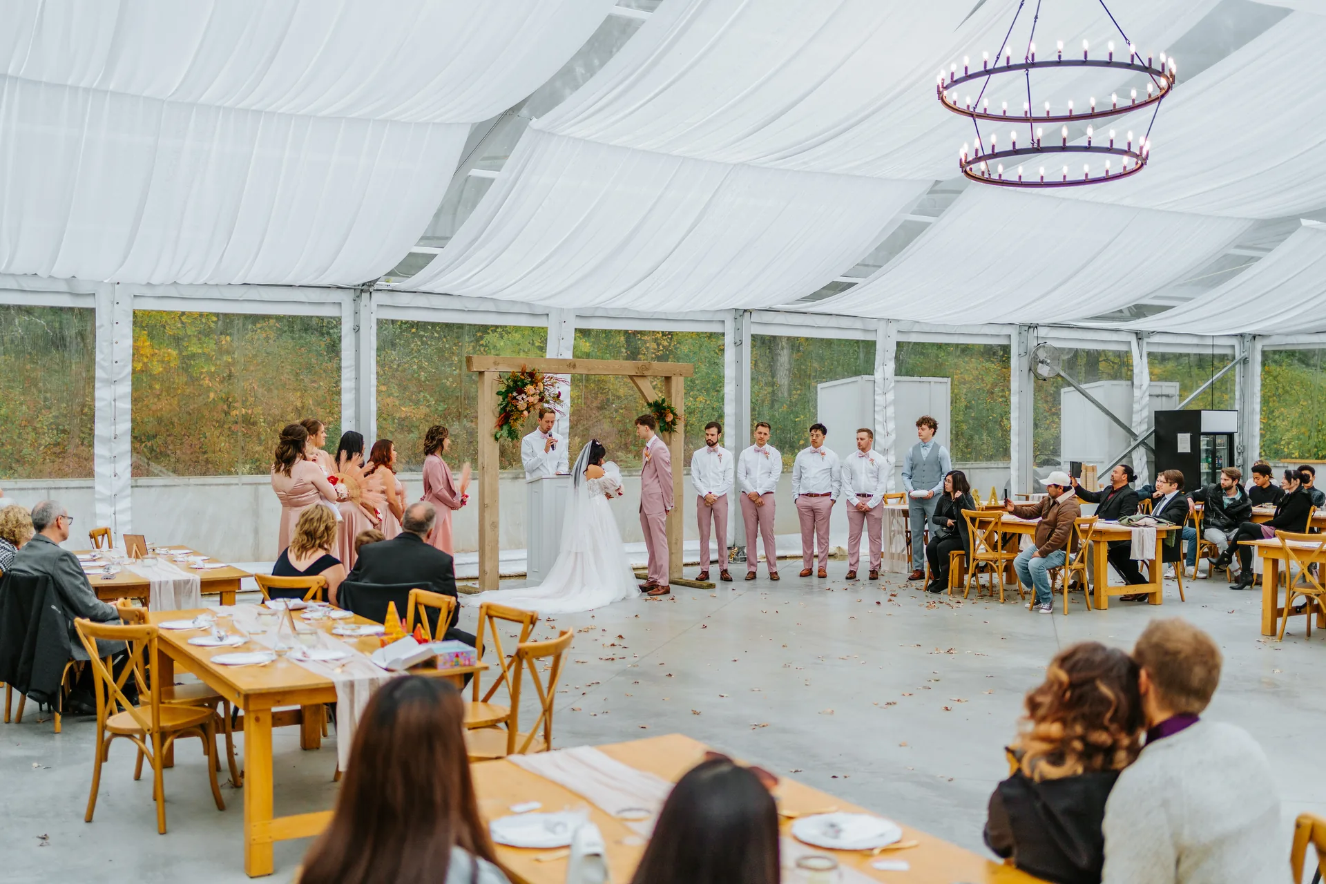 Paola and Riley recessional just married through confetti inside the glass tent at Oakland Estates Manitoba wedding