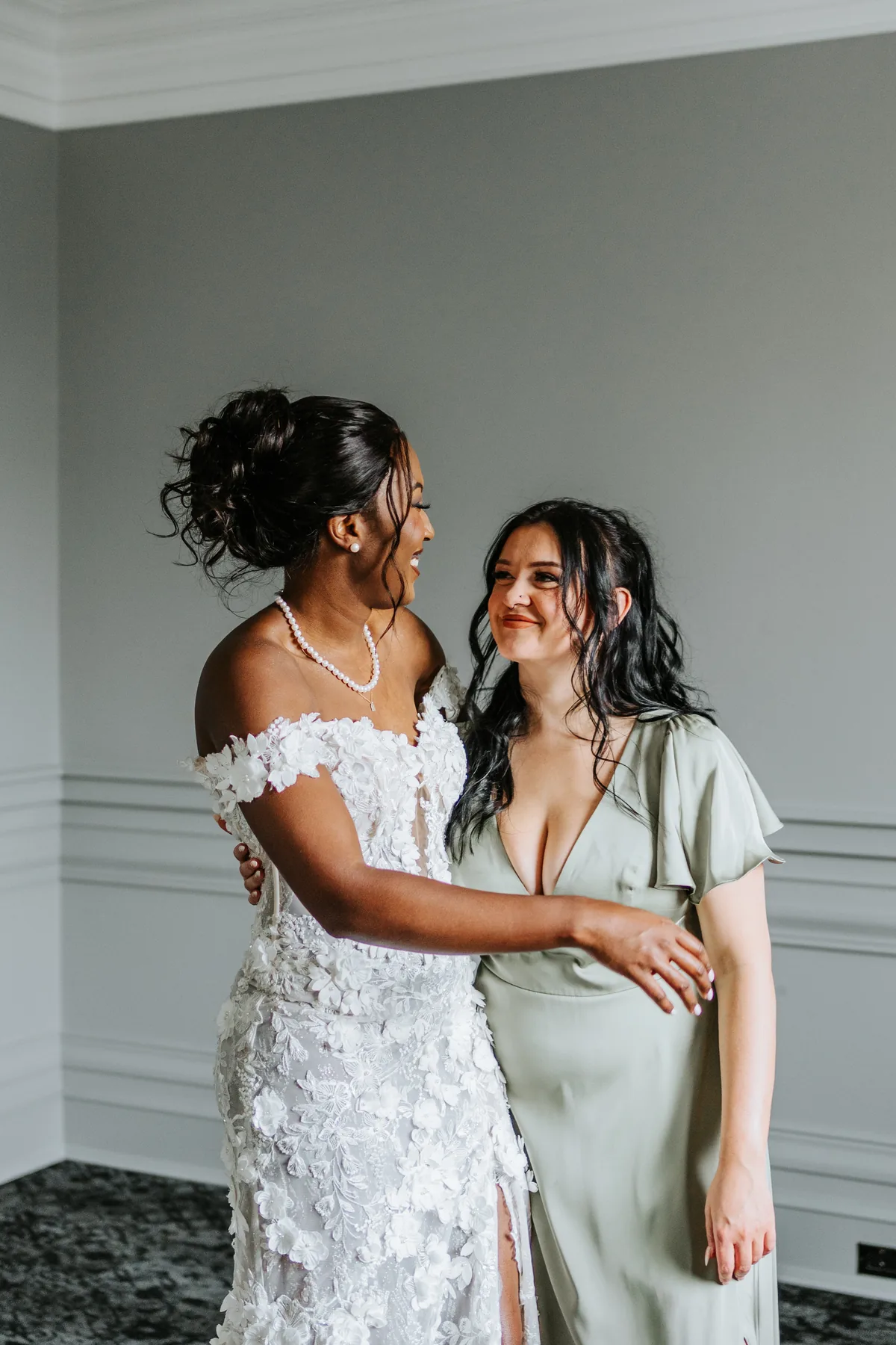 Bride and bridesmaid sharing an emotional moment while getting ready at the Fort Garry Hotel, Winnipeg