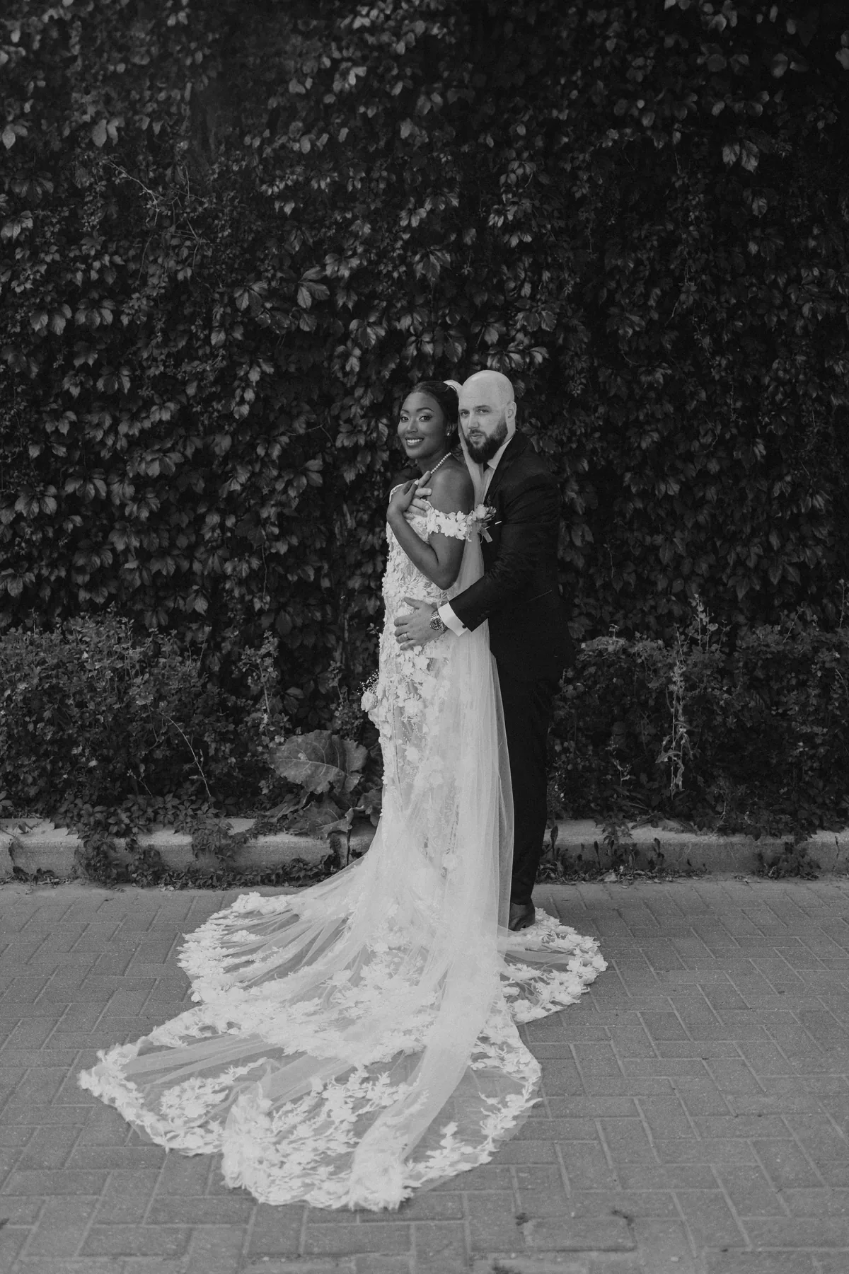 Bride's cathedral veil trailing against the ivy wall at The Forks, Winnipeg