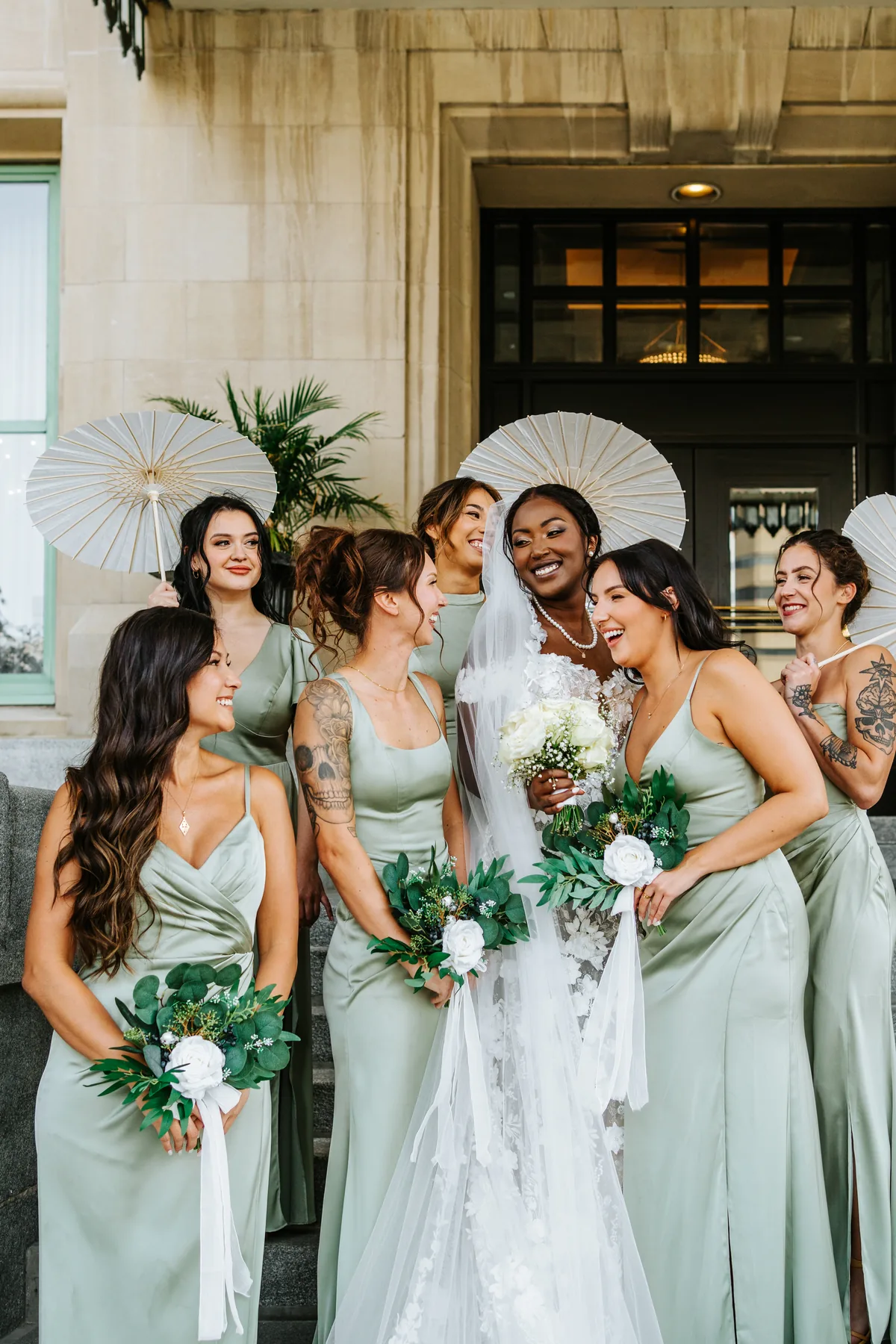 Bridesmaids with white parasols outside the Fort Garry Hotel entrance, Winnipeg