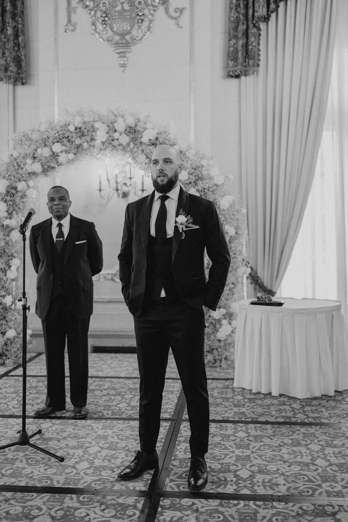 Groom waiting at the floral arch altar in the Provencher Ballroom at the Fort Garry Hotel, Winnipeg