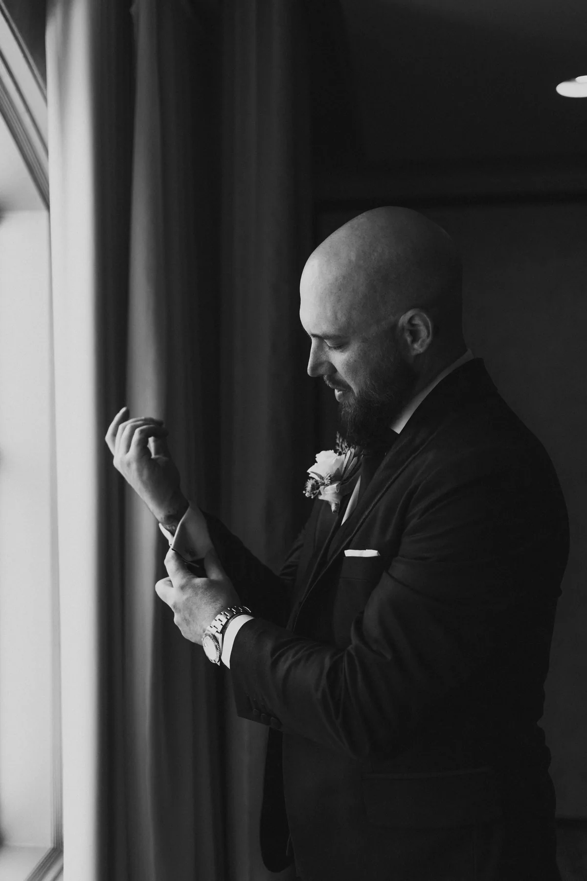 Groom adjusting cufflinks at the Fort Garry Hotel window on his wedding morning, Winnipeg