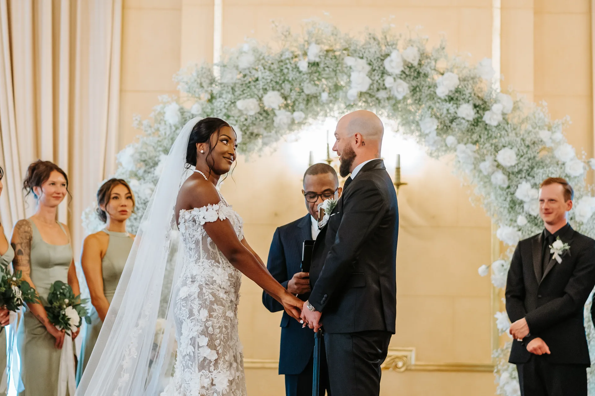 Wedding vows at the white rose floral arch in the Provencher Ballroom at the Fort Garry Hotel, Winnipeg