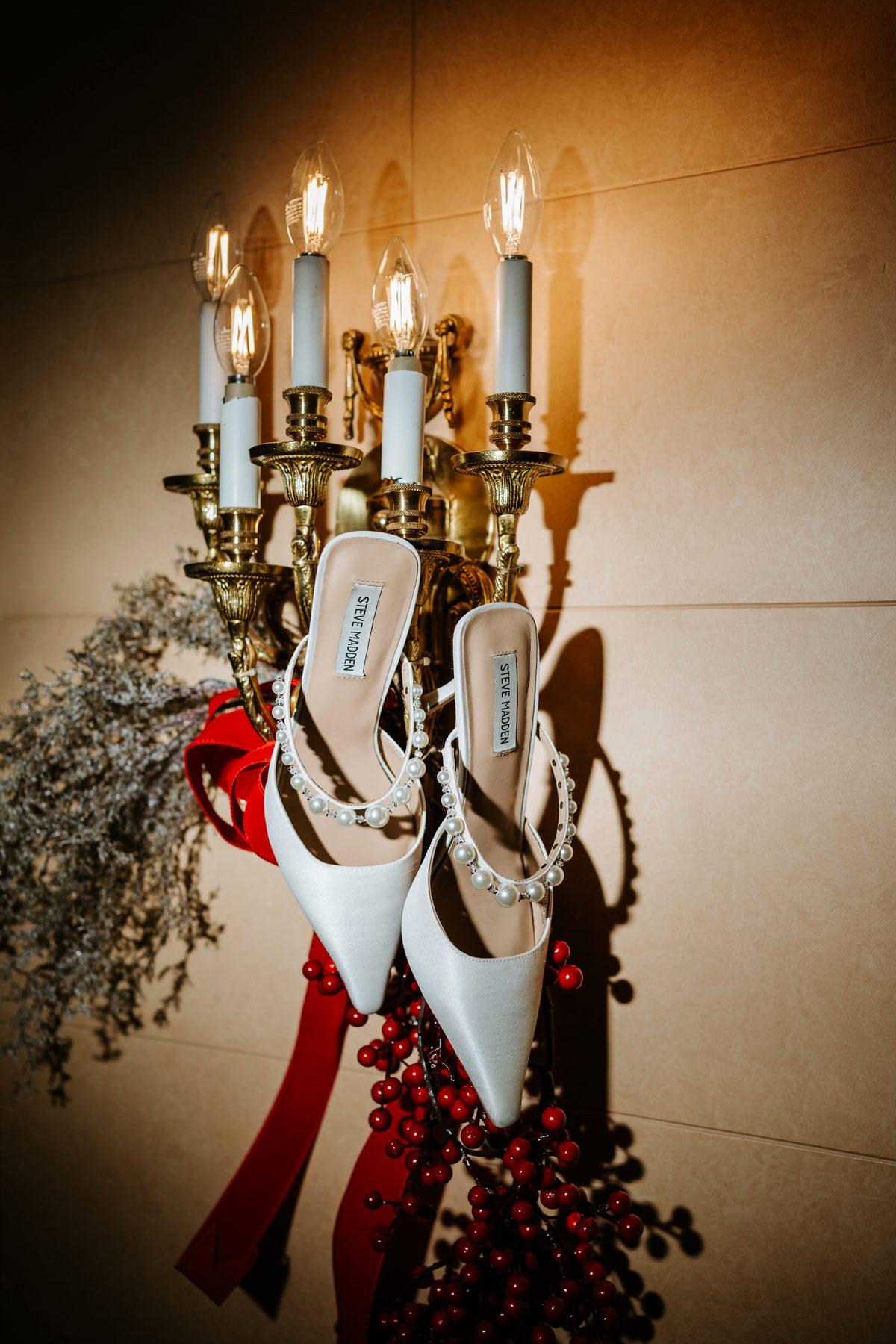 Bridal heels beside a candelabra at The Fort Garry Hotel Winnipeg — wedding detail photography by Chris Ngo