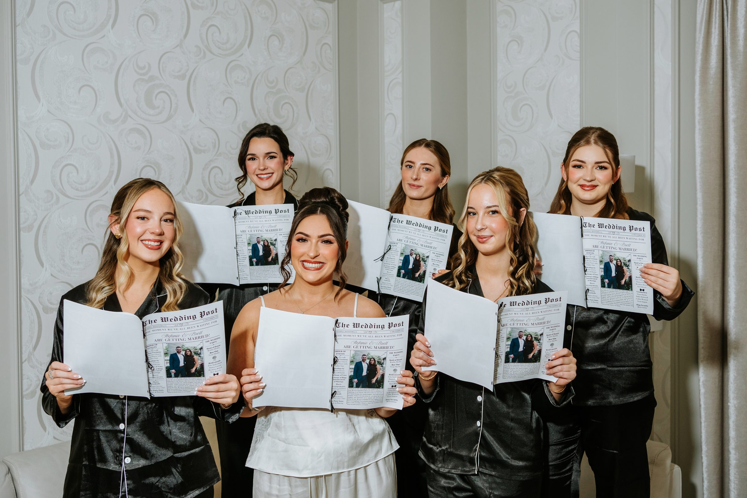 Stef and her bridesmaids holding custom wedding newspapers during getting ready — Winnipeg wedding photography by Chris Ngo