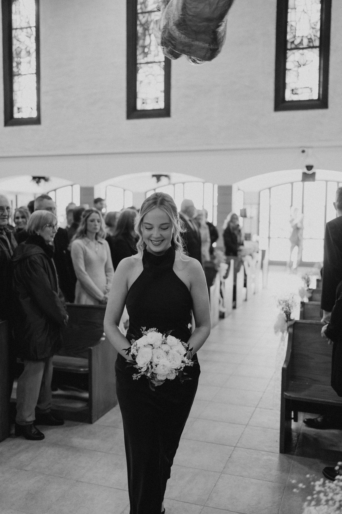 Bridesmaid walking down the aisle at Holy Rosary Church, Winnipeg