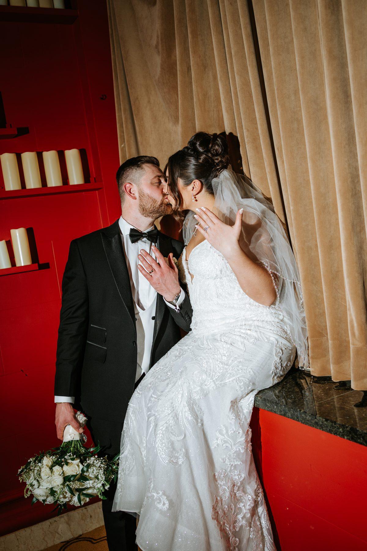Couple sharing a kiss in candlelight at The Fort Garry Hotel wedding reception Winnipeg — photography by Chris Ngo