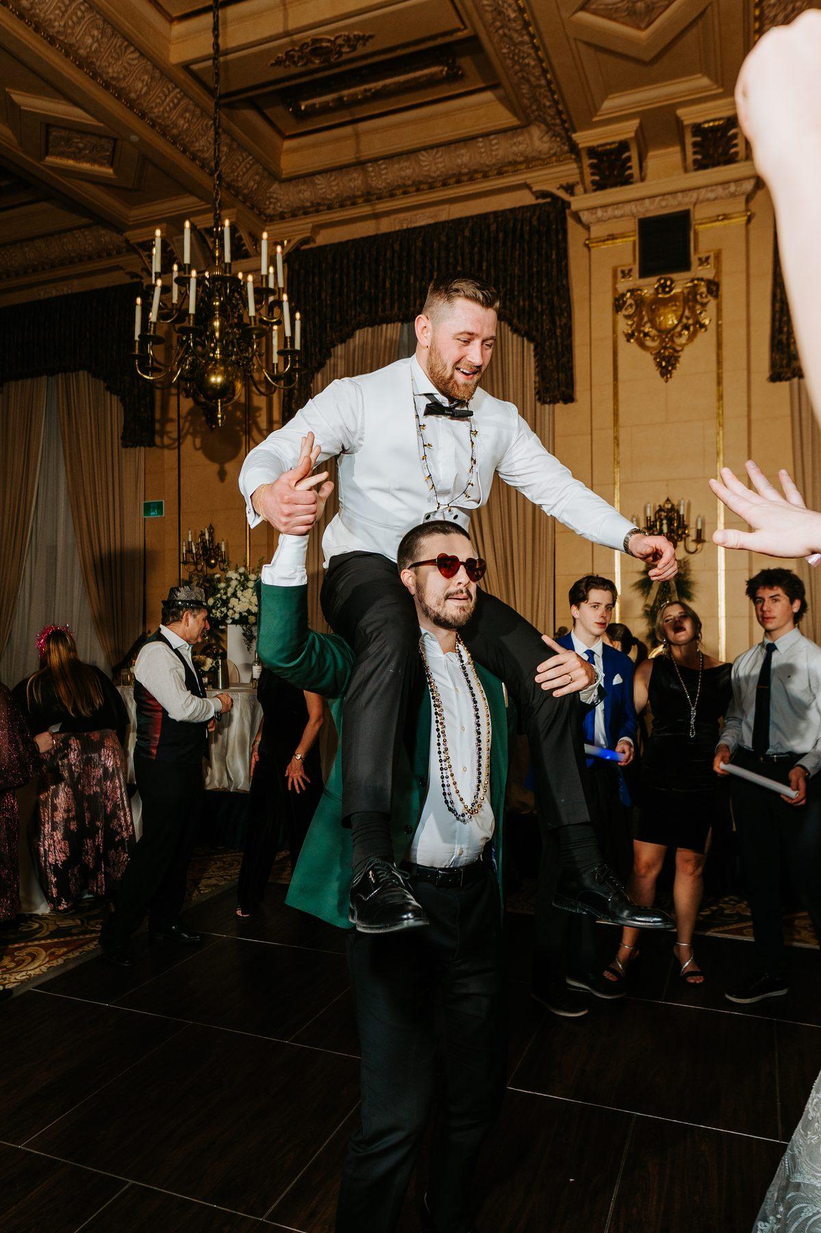 Groom lifting bride on his shoulders at the New Year's Eve midnight celebration at The Fort Garry Hotel Winnipeg — Ngo Photography