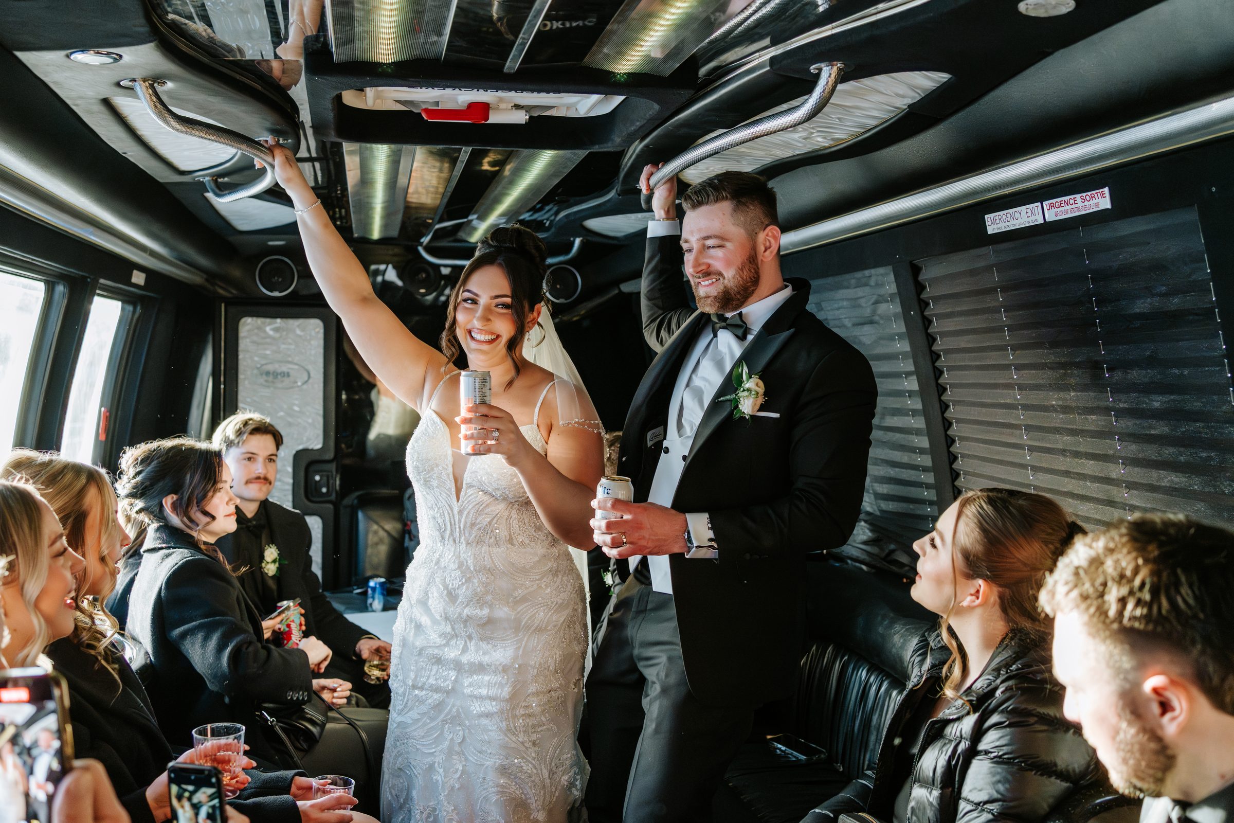 Stef and Brett's wedding party celebrating on the party bus between the ceremony and CMHR portraits — Winnipeg wedding photography by Chris Ngo