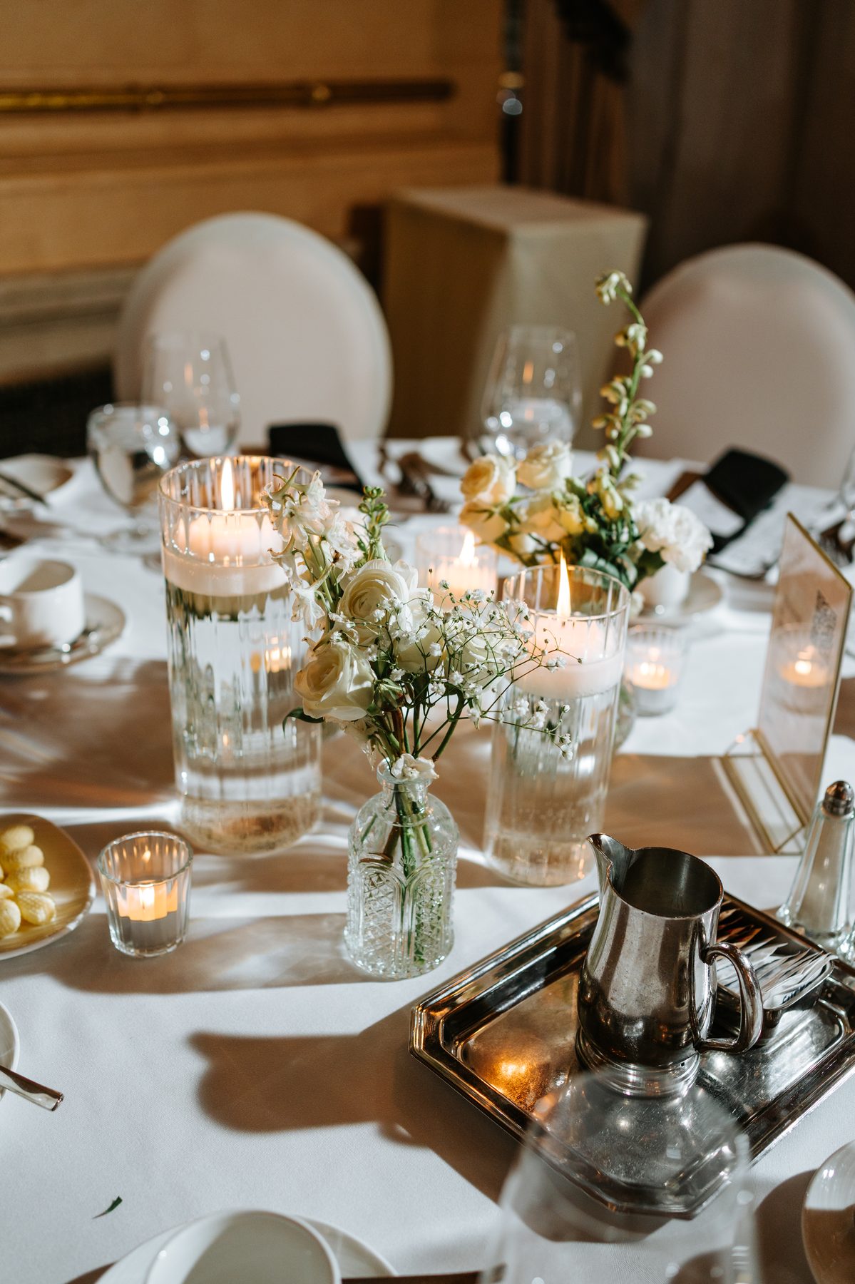 Wedding reception centerpiece with candles and florals at The Fort Garry Hotel Winnipeg — detail photography by Chris Ngo, Ngo Photography