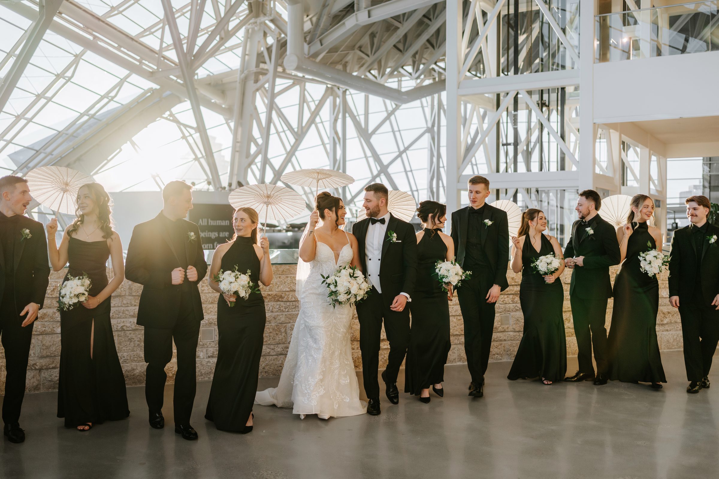 Stef and Brett with their wedding party at the Canadian Museum for Human Rights Winnipeg — golden hour portrait by Chris Ngo
