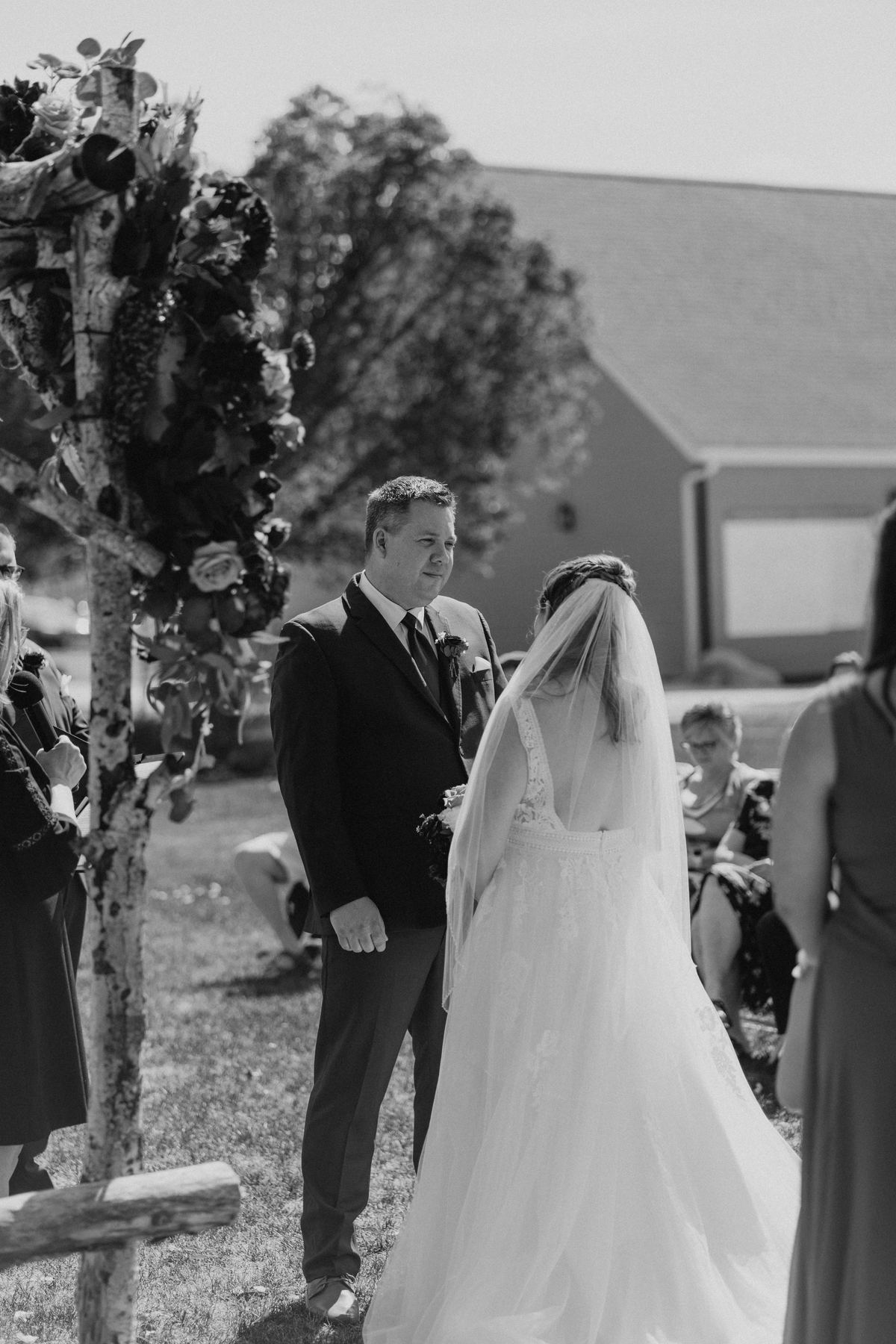 Tara and Carter vows under the driftwood and floral arbor in the perennial garden at Pineridge Hollow, Winnipeg — Ngo Photography