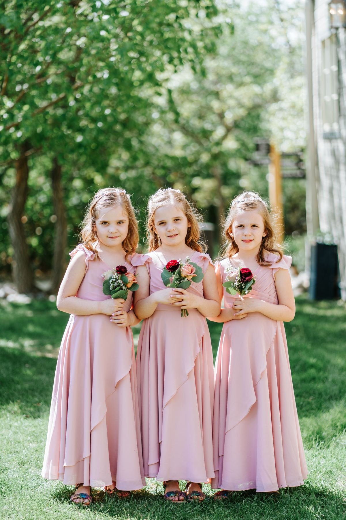 Three flower girls in blush pink dresses with mini bouquets at Pineridge Hollow, Pine Ridge, Manitoba — Ngo Photography