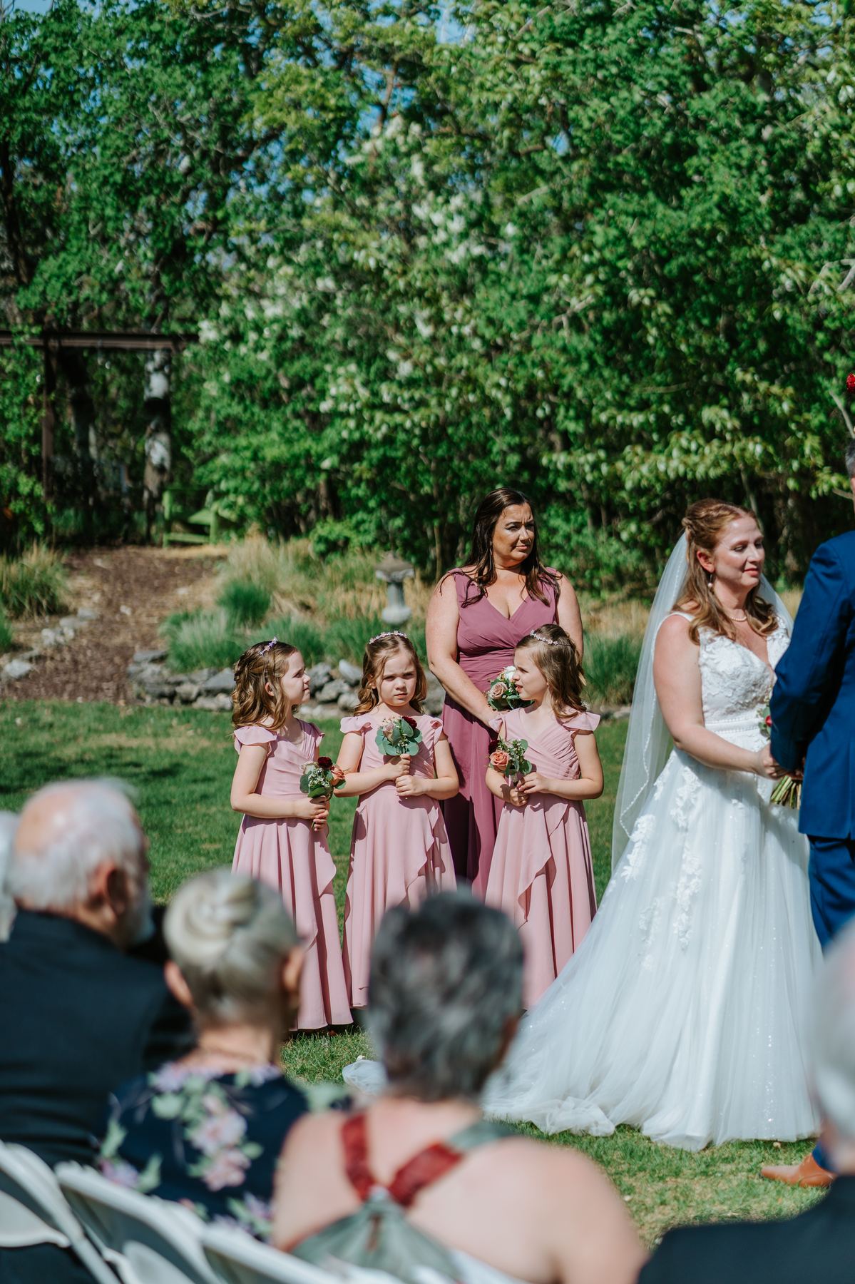 Flower girls and bridesmaids during the garden ceremony at Pineridge Hollow, Pine Ridge, Manitoba — Ngo Photography
