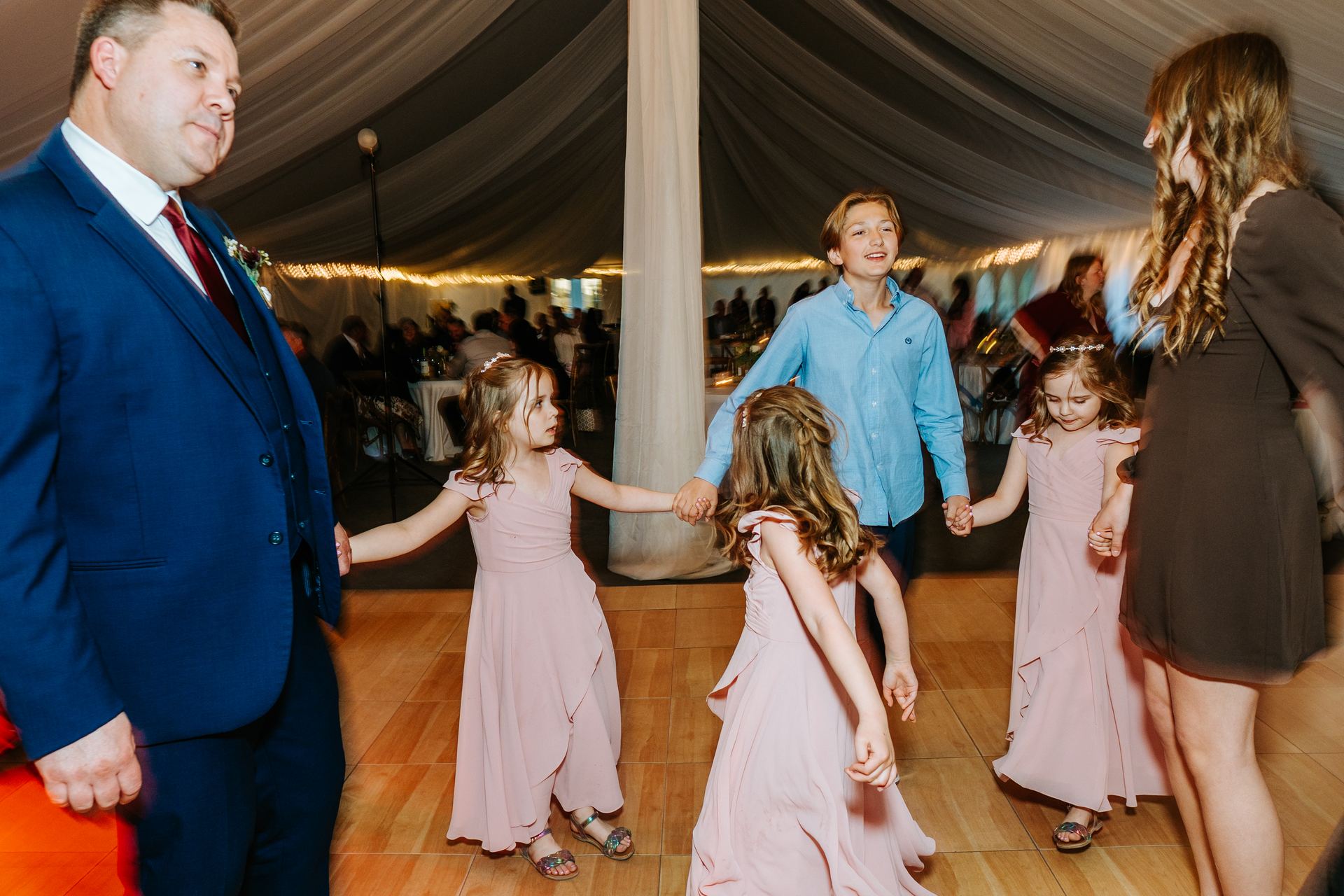Flower girls dancing at the reception in the white canvas pavilion at Pineridge Hollow, Pine Ridge, Winnipeg