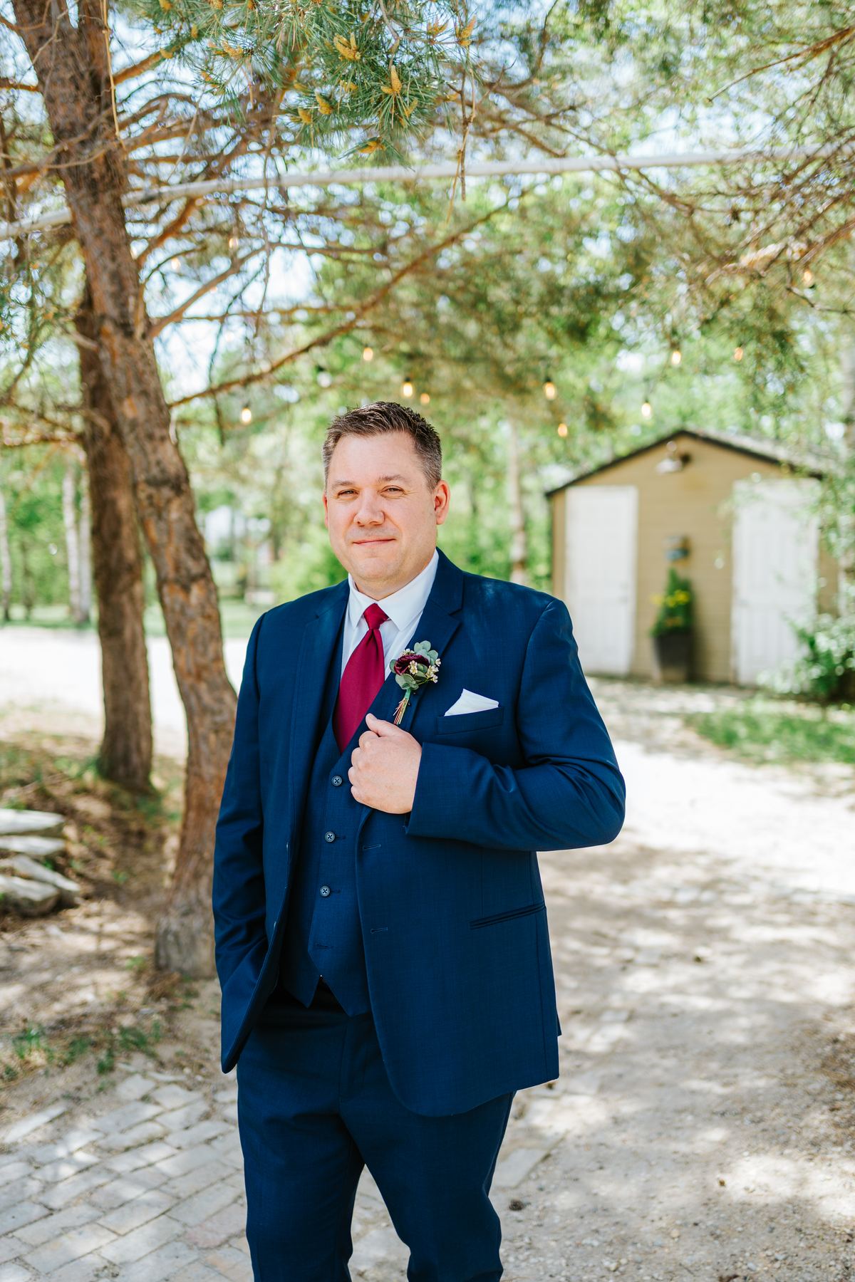 Groom Carter portrait in navy three-piece suit at Pineridge Hollow, Pine Ridge, Manitoba — Ngo Photography