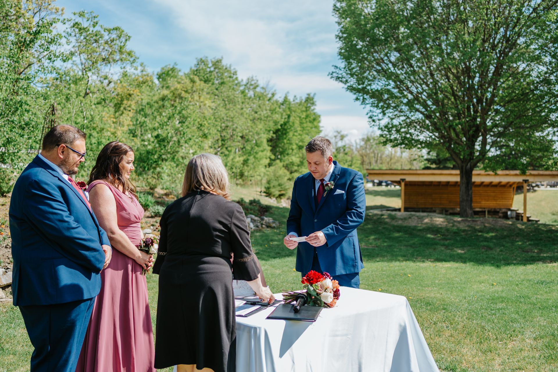Ring exchange during the ceremony in the perennial garden at Pineridge Hollow, Pine Ridge, Manitoba