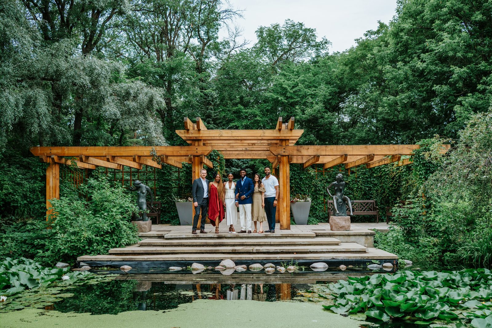 Emeka and Tobi sharing a quiet moment together with champagne glasses at Leo Mol Sculpture Garden — Winnipeg intimate wedding photography