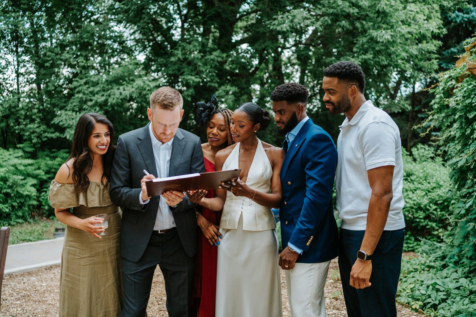 Close-up of Tobi and Emeka signing the marriage licence at Leo Mol Sculpture Garden — documentary moment, Winnipeg wedding photography
