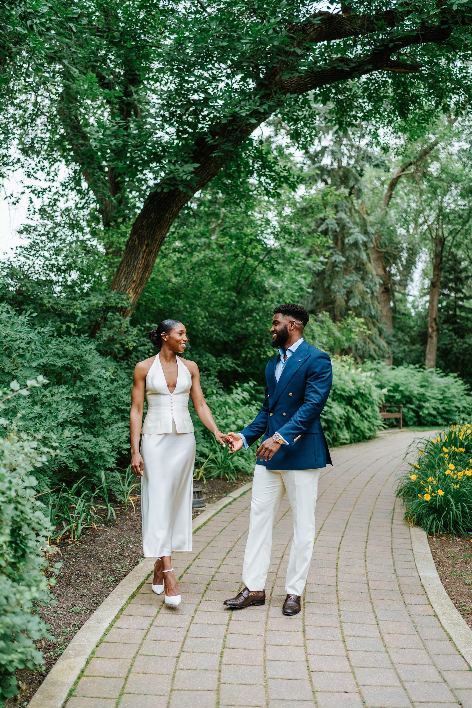 Close-up of Tobi and Emeka during the vow exchange at Leo Mol Sculpture Garden, Assiniboine Park, Winnipeg — intimate ceremony photography