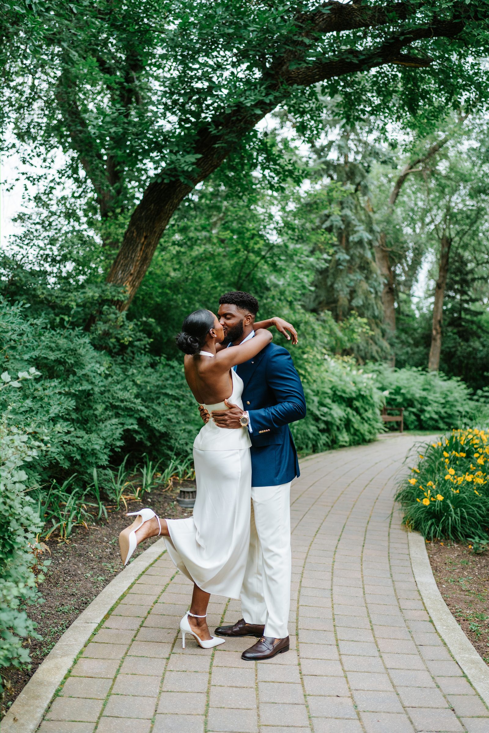 Tobi and Emeka looking at each other during their ceremony at Leo Mol Sculpture Garden — Assiniboine Park, Winnipeg wedding photography by Ngo Photography