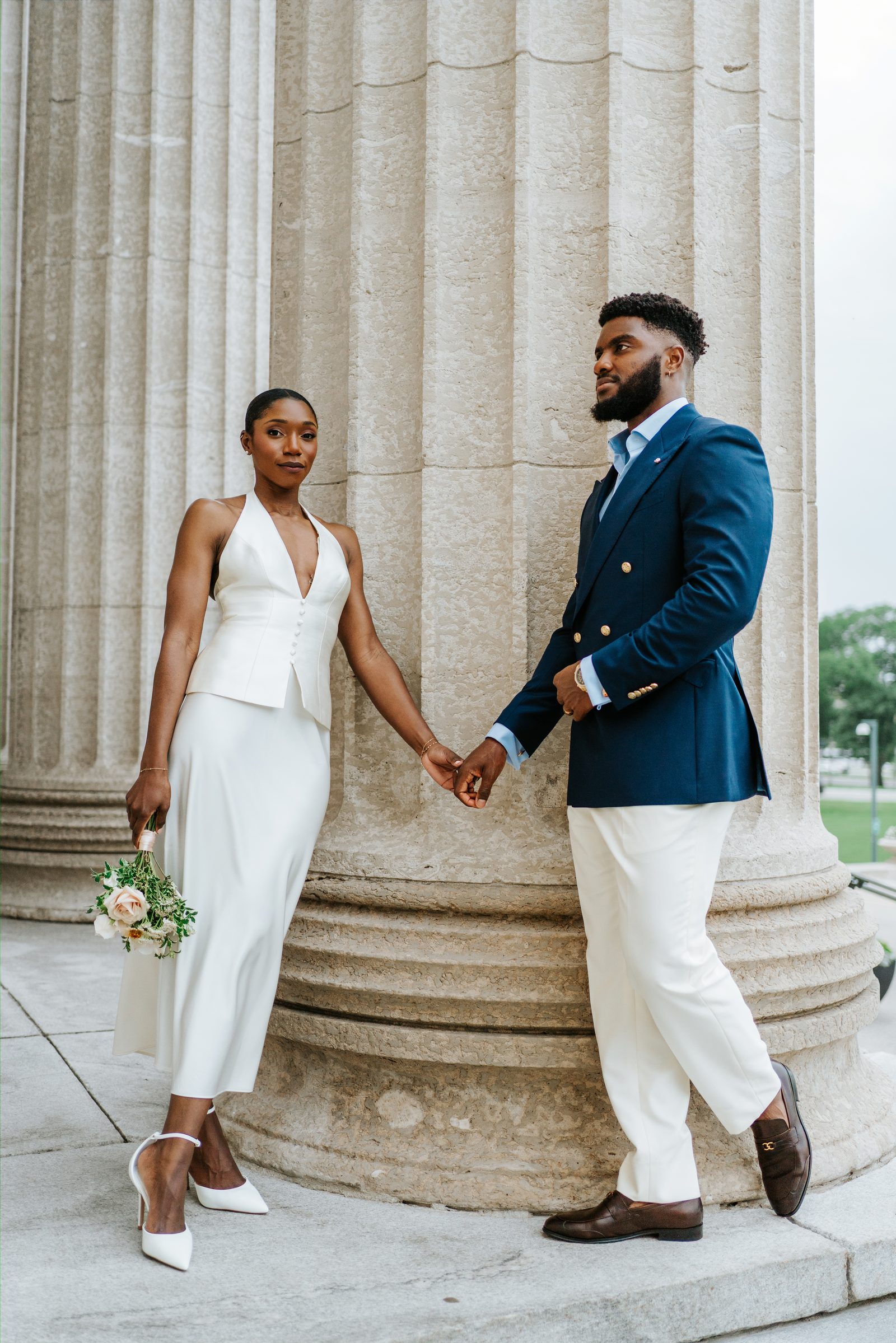 Tobi and a guest on the exterior steps of the Manitoba Legislative Building, Winnipeg — candid moment between stone columns